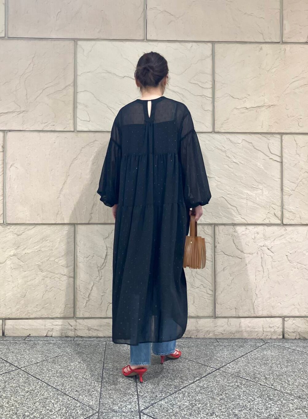 ブラック系のワンピース、イエロー系のハンドバッグを着用したレディースの春コーディネートの2枚目の写真