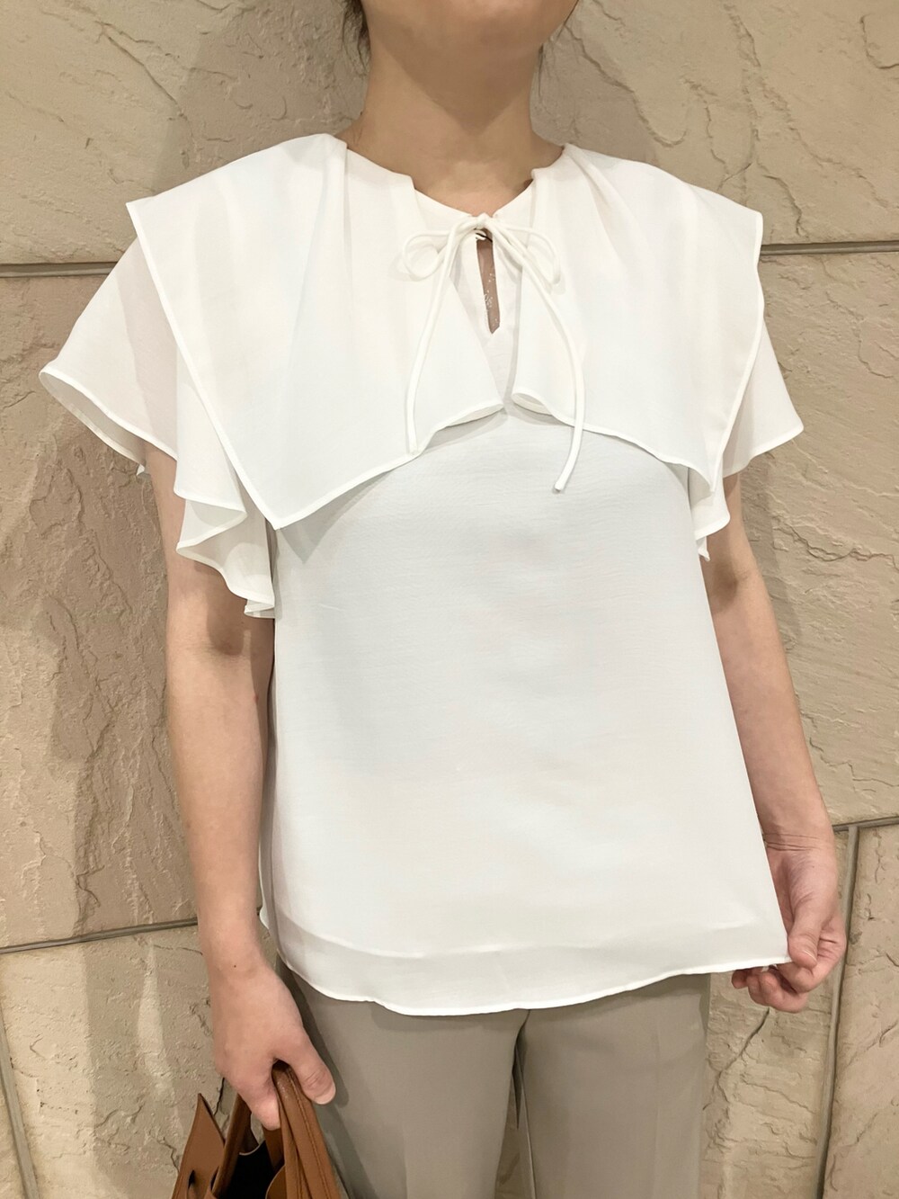 ホワイト系のシャツ/ブラウス、ベージュ系のその他パンツ、ブラウン系のバッグを着用したレディースの夏コーディネートの4枚目の写真