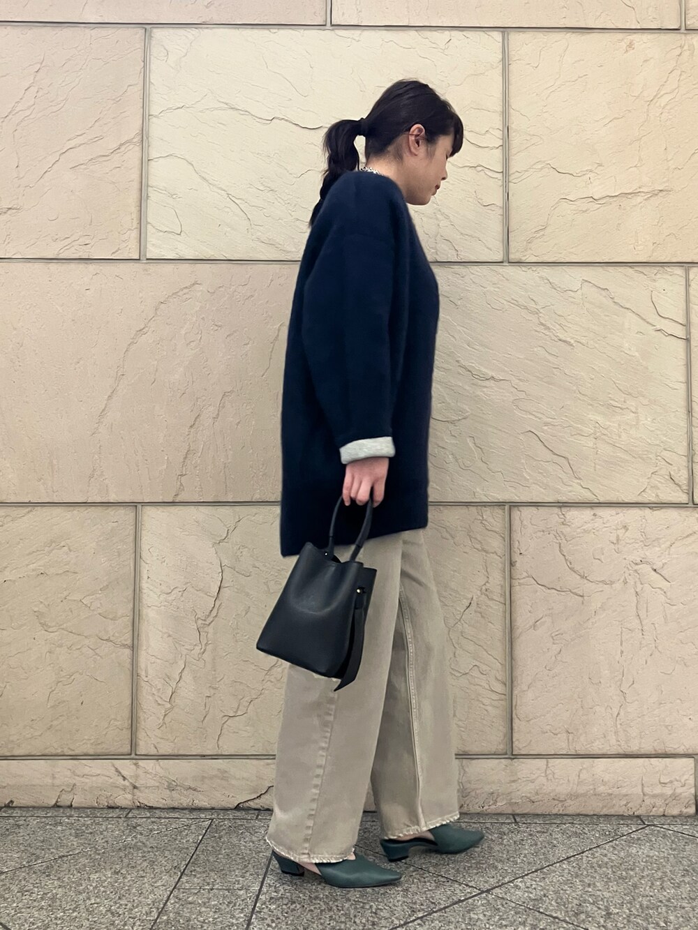 グレー系のTシャツ/カットソー、ベージュ系のデニムパンツ、ブラック系のハンドバッグを着用したレディースの秋コーディネートの2枚目の写真
