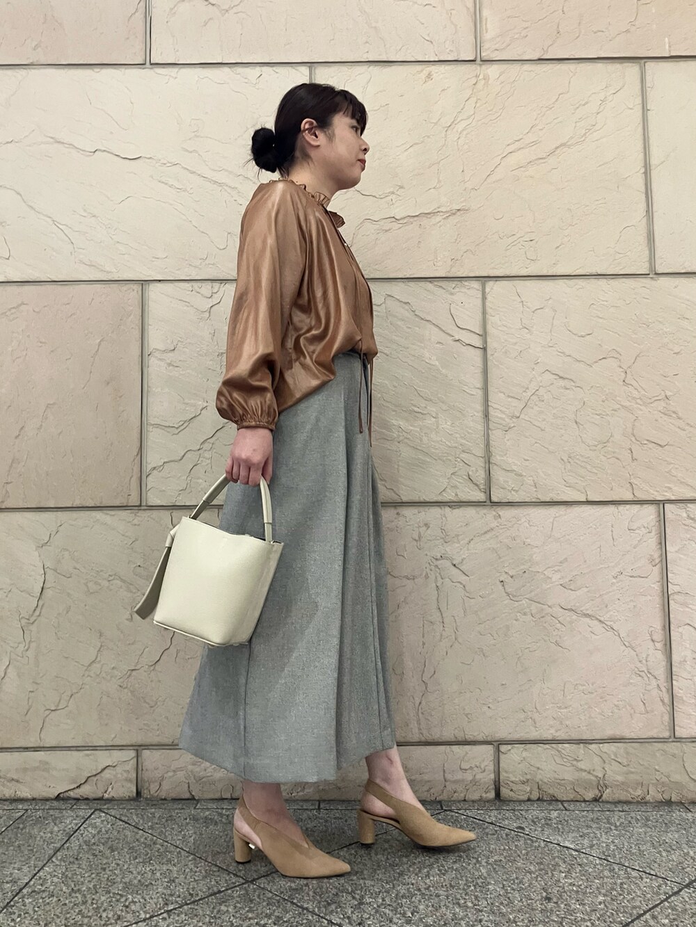 イエロー系のシャツ/ブラウス、グレー系のスカート、ホワイト系のバッグを着用したレディースの秋コーディネートの2枚目の写真