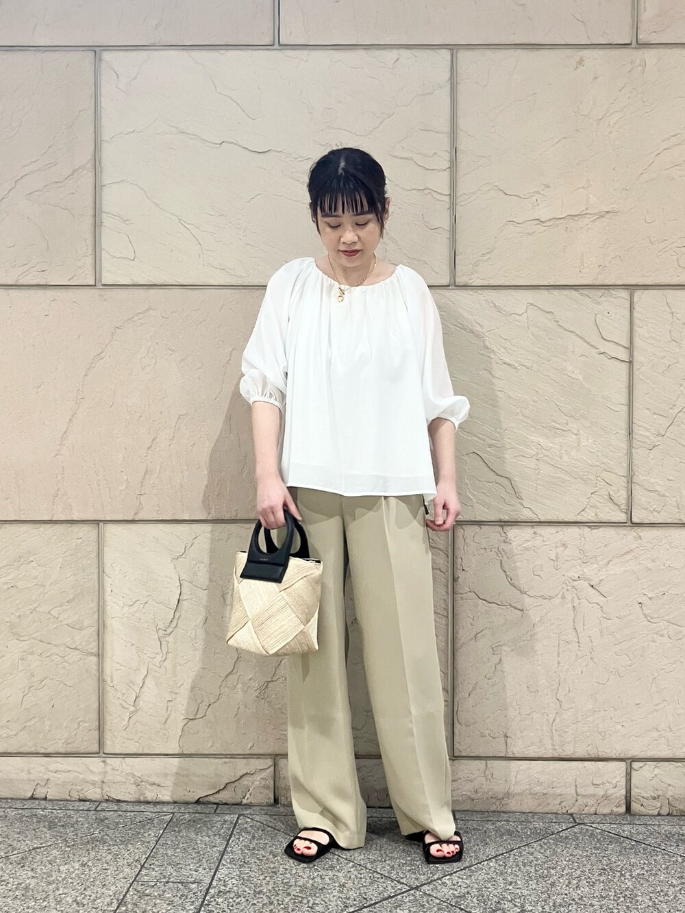 ホワイト系のシャツ/ブラウス、ベージュ系のその他パンツ、ブラック系のかごバッグを着用したレディースの春コーディネートの2枚目の写真