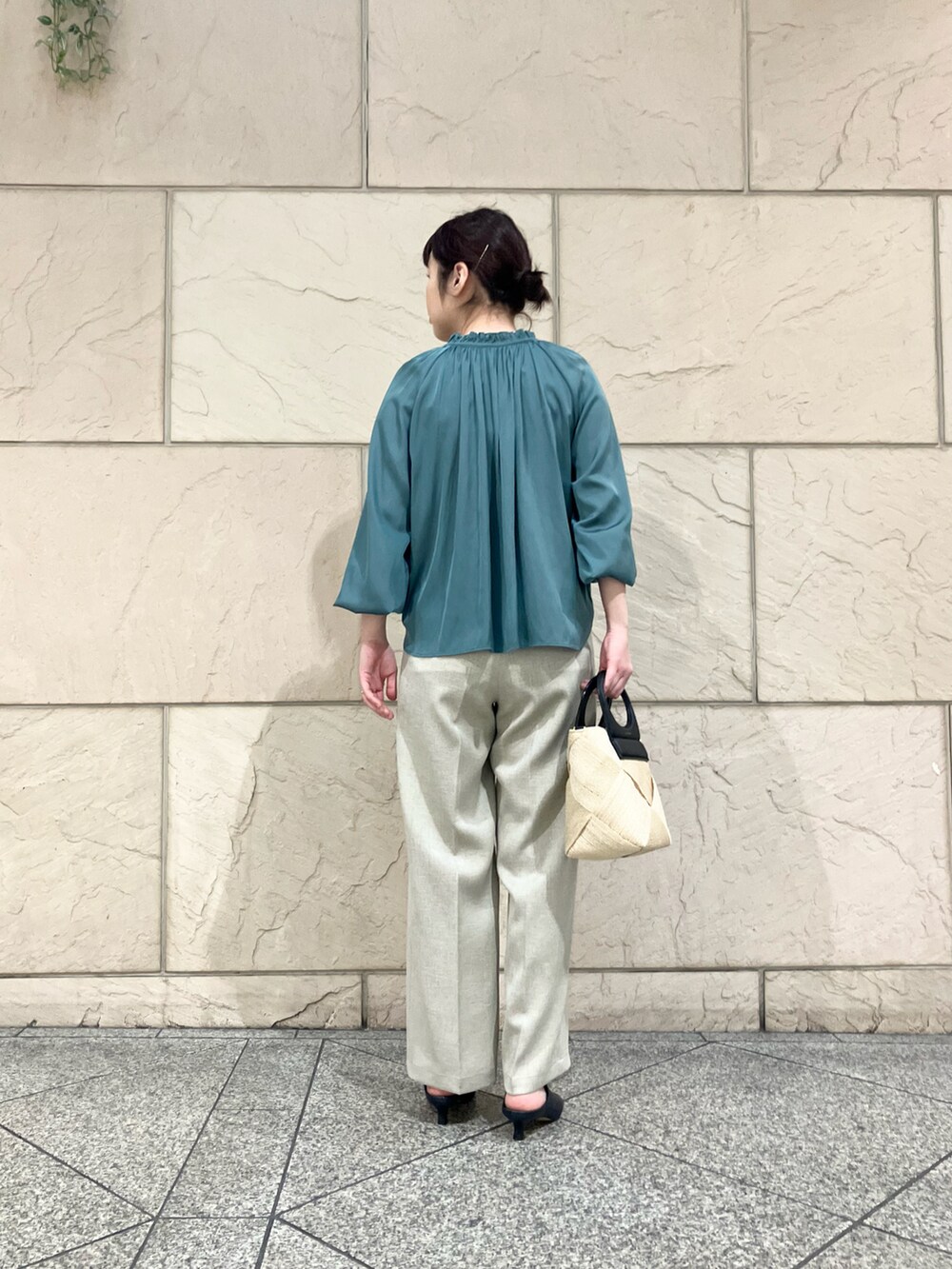 グリーン系のシャツ/ブラウス、ベージュ系のパンツ、ベージュ系のハンドバッグを着用したレディースの春コーディネートの2枚目の写真