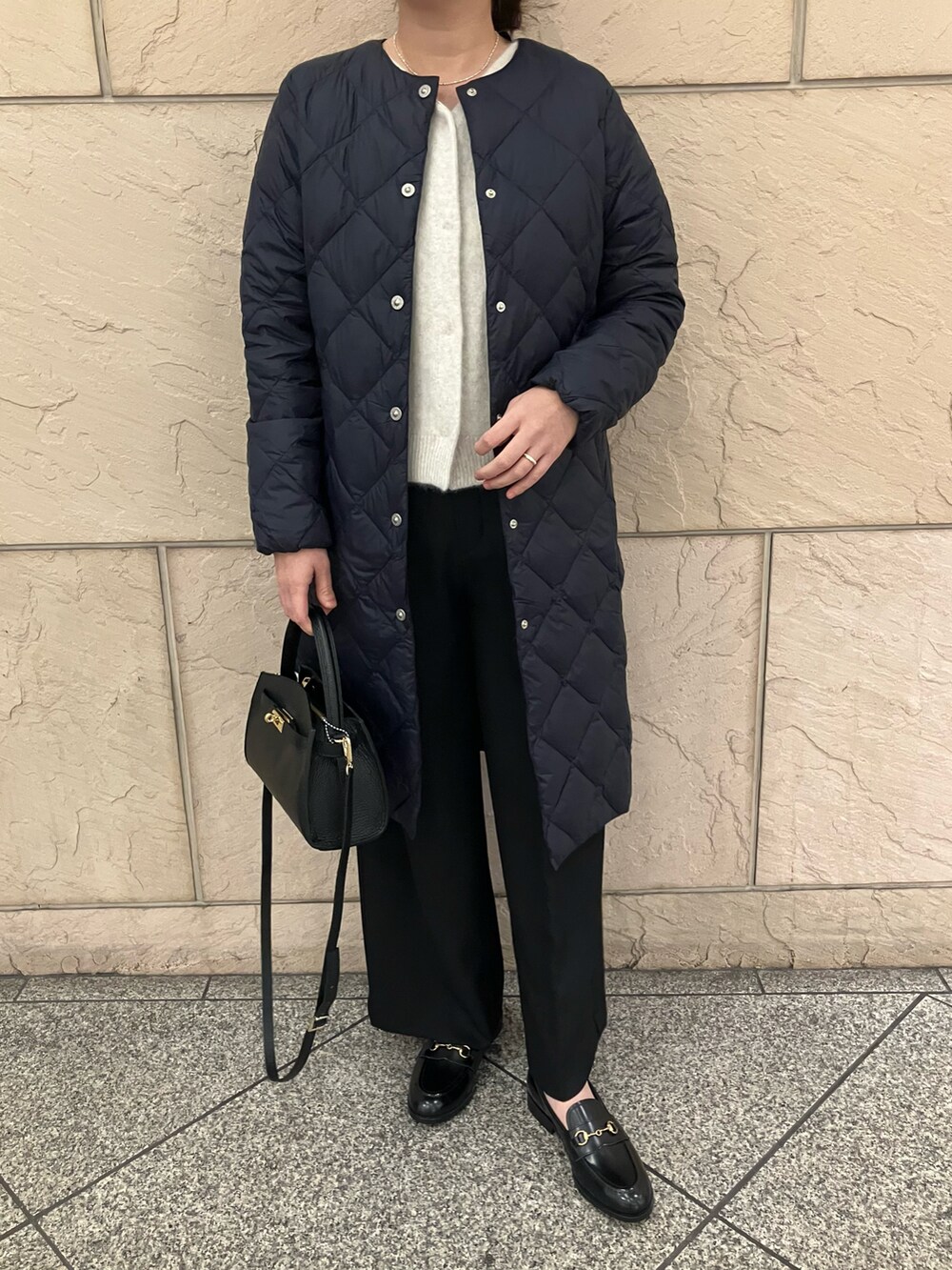 ホワイト系のカーディガン/ボレロ、ブラック系のパンツ、ブラック系のバッグを着用したレディースの秋コーディネートの4枚目の写真