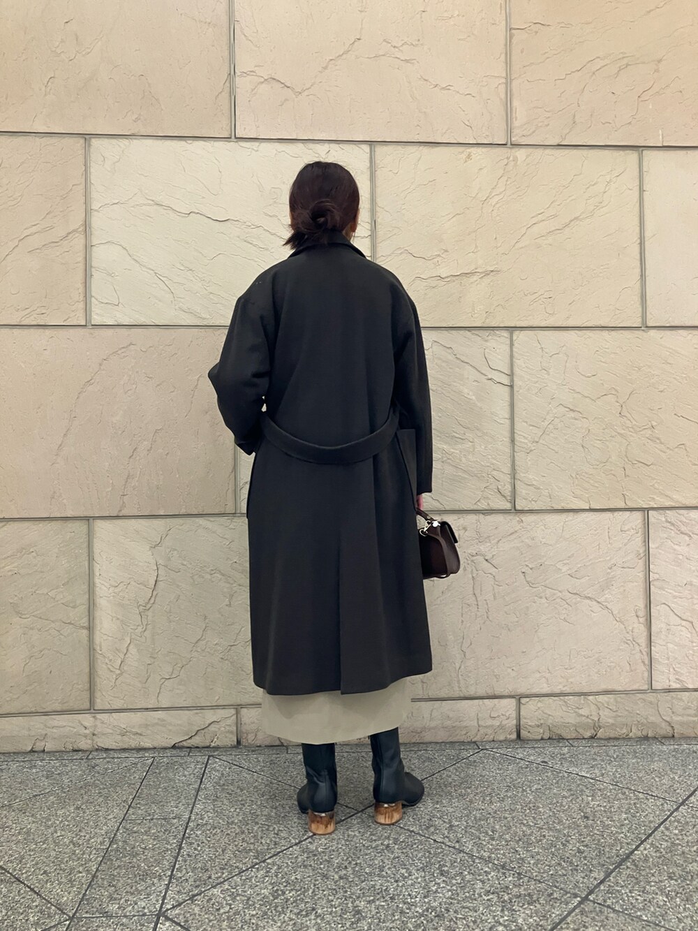 グリーン系のニット/セーター、ブラウン系のその他アウター、ベージュ系のスカートを着用したレディースの冬コーディネートの3枚目の写真