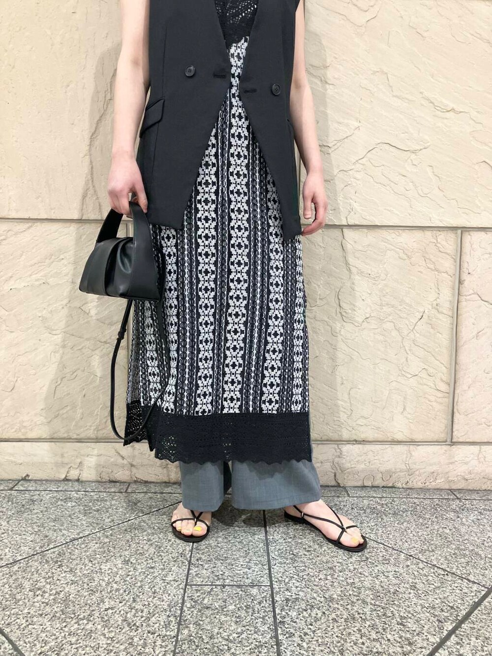 グレー系のその他パンツ、ブラック系のハンドバッグ、グレー系のベストを着用したレディースの春コーディネートの4枚目の写真