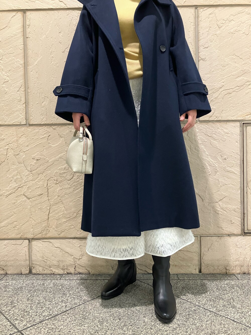 ブルー系のその他アウター、イエロー系のニット/セーター、ホワイト系のスカートを着用したレディースの秋コーディネートの4枚目の写真