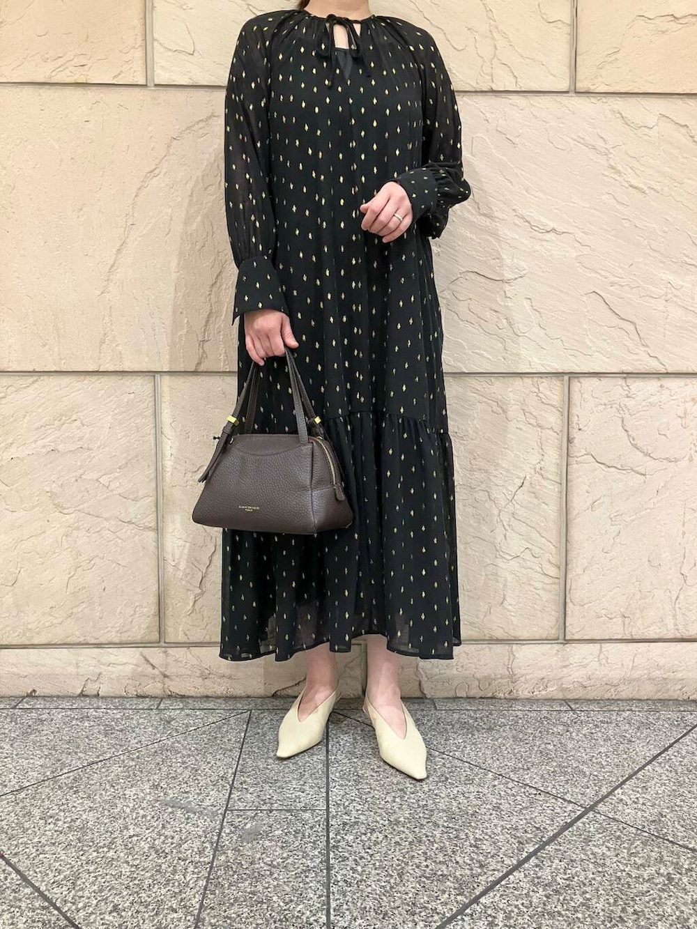 ブラック系のワンピース、ベージュ系のパンプス、ブラウン系のバッグを着用したレディースの夏コーディネートの5枚目の写真
