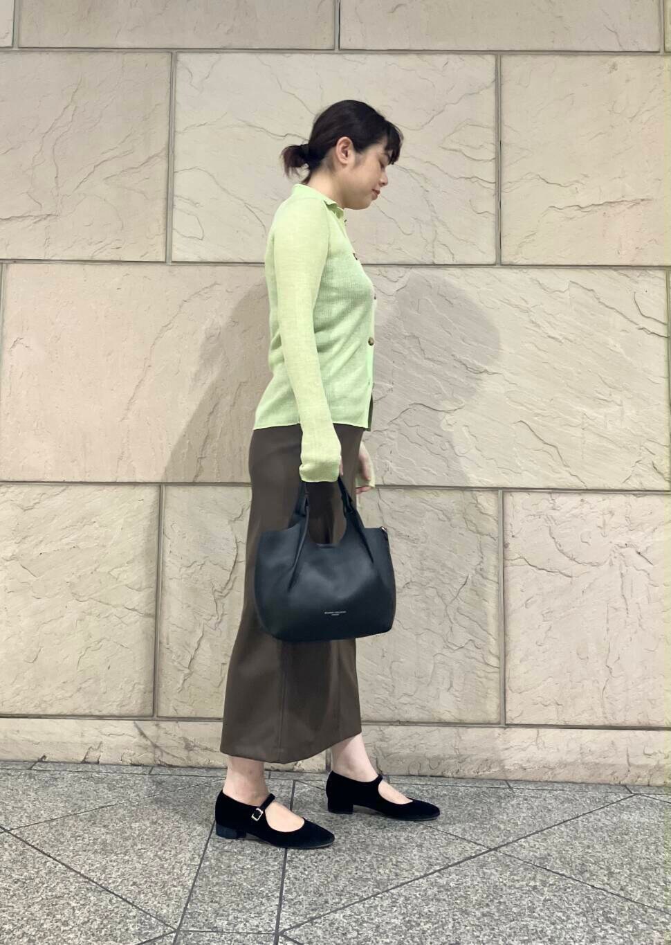 ブラウン系のスカート、イエロー系のニット/セーター、ブラック系のパンプスを着用したレディースの夏コーディネートの2枚目の写真