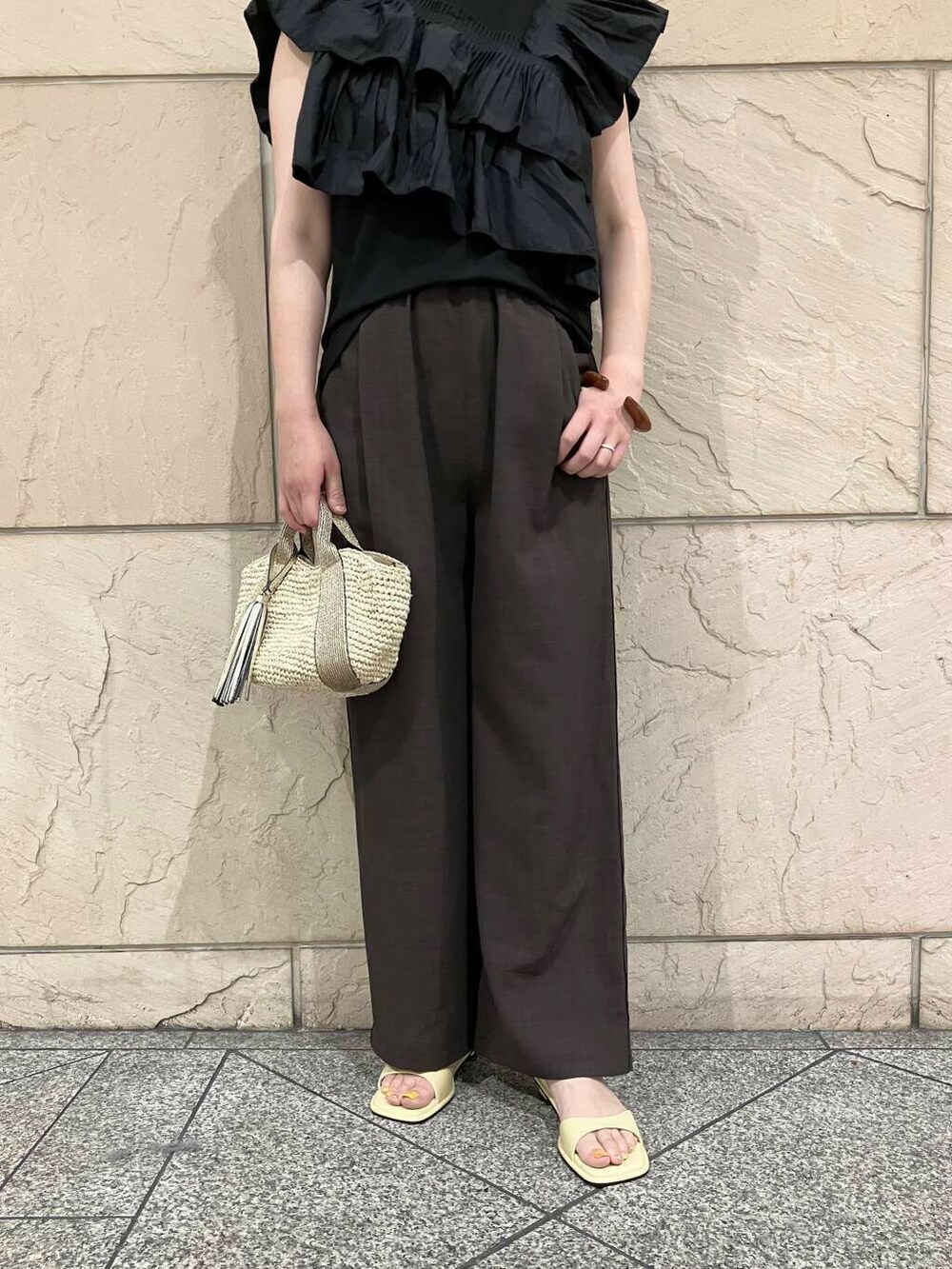 ベージュ系のかごバッグ、イエロー系のサンダル、ブラック系のTシャツ/カットソーを着用したレディースの夏コーディネートの5枚目の写真