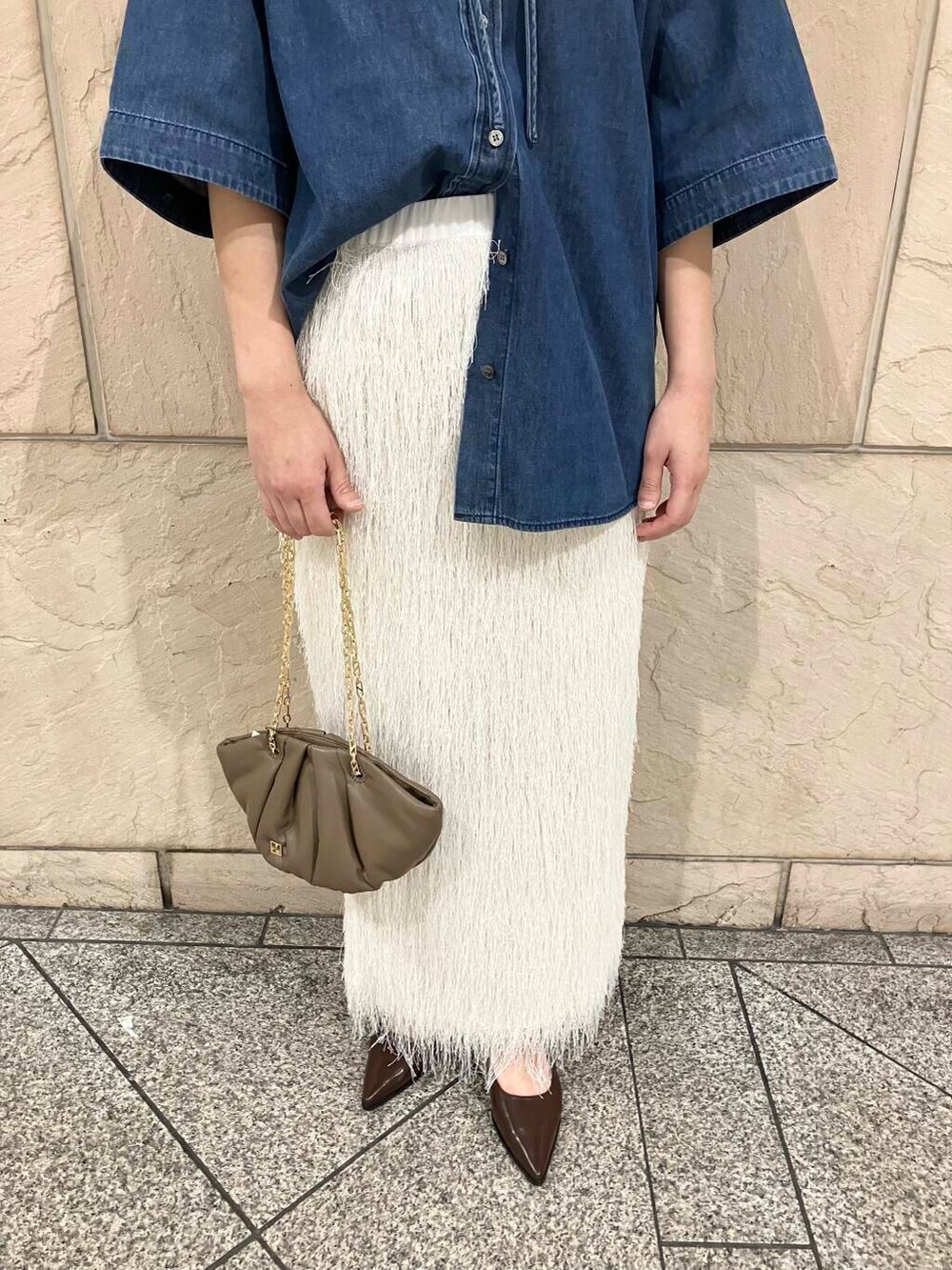 ブルー系のシャツ/ブラウス、ブラウン系のハンドバッグ、ホワイト系のスカートを着用したレディースの夏コーディネートの4枚目の写真