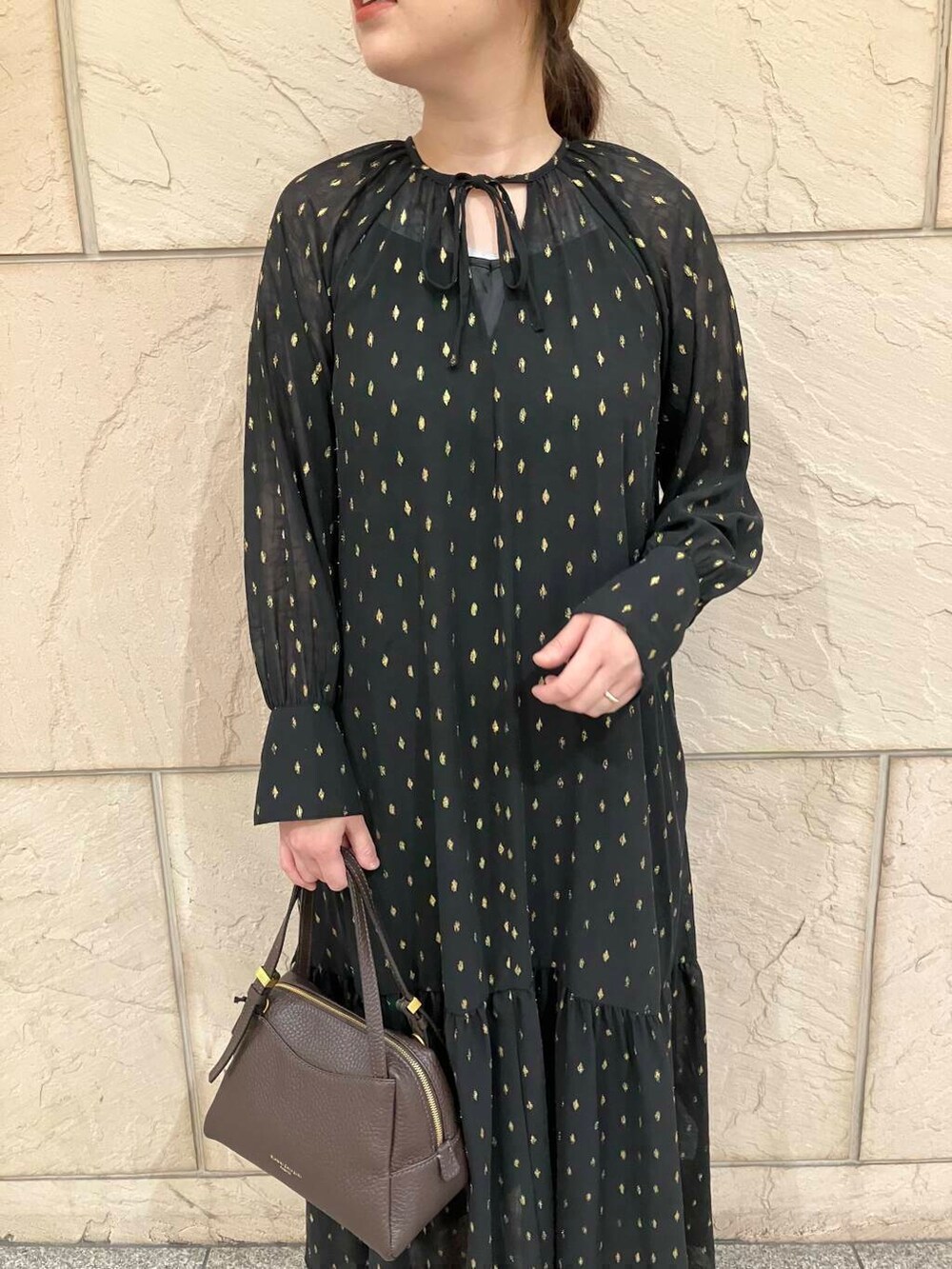 ブラック系のワンピース、ベージュ系のパンプス、ブラウン系のバッグを着用したレディースの夏コーディネートの4枚目の写真