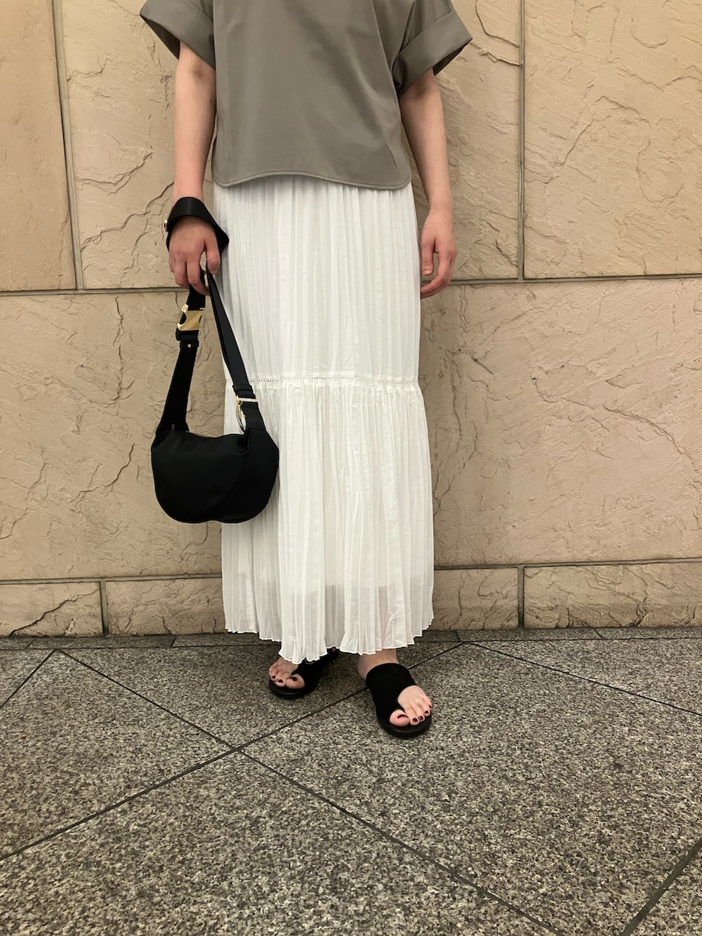 ブラウン系のTシャツ/カットソー、ホワイト系のスカート、ブラック系のショルダーバッグを着用したレディースの夏コーディネートの5枚目の写真