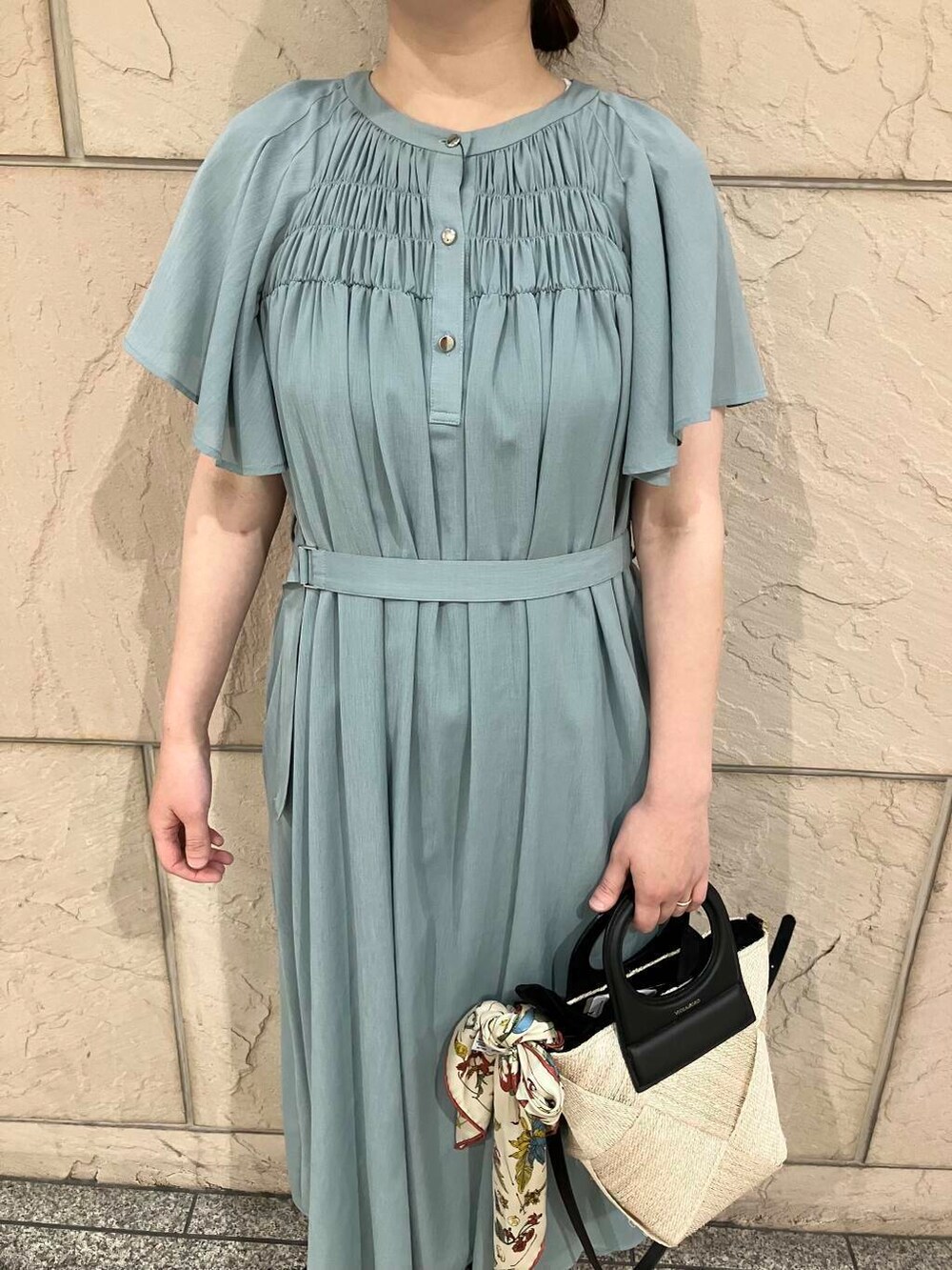 ベージュ系のショルダーバッグ、ブルー系のワンピース、ホワイト系のバンダナ/スカーフを着用したレディースの春コーディネートの4枚目の写真