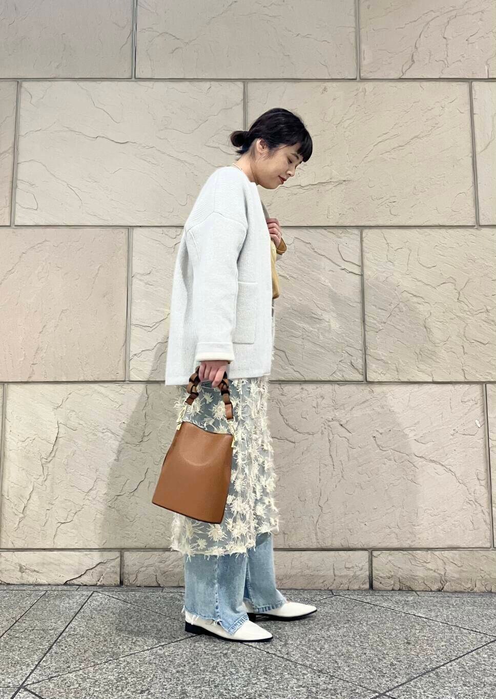 ブルー系のデニムパンツ、グレー系のカーディガン/ボレロ、イエロー系のシャツ/ブラウスを着用したレディースの秋コーディネートの2枚目の写真