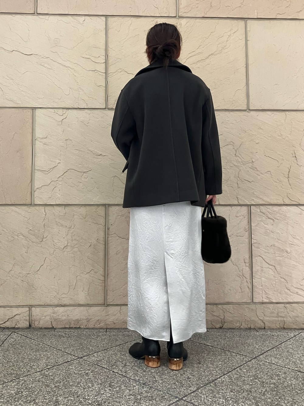 グレー系のニット/セーター、グレー系のピーコート、ブラウン系のハンドバッグを着用したレディースの秋コーディネートの3枚目の写真