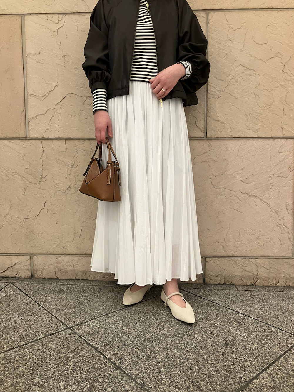 ホワイト系のTシャツ/カットソー、ブラウン系のブルゾン、ホワイト系のスカートを着用したレディースの春コーディネートの5枚目の写真