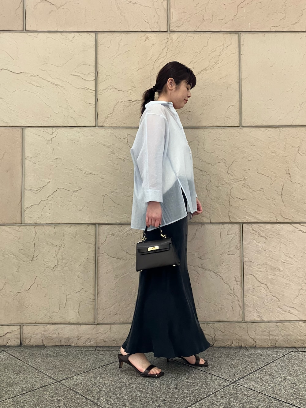 ホワイト系のキャミソール、ブラック系のスカート、ブルー系のトップスを着用したレディースの春コーディネートの2枚目の写真