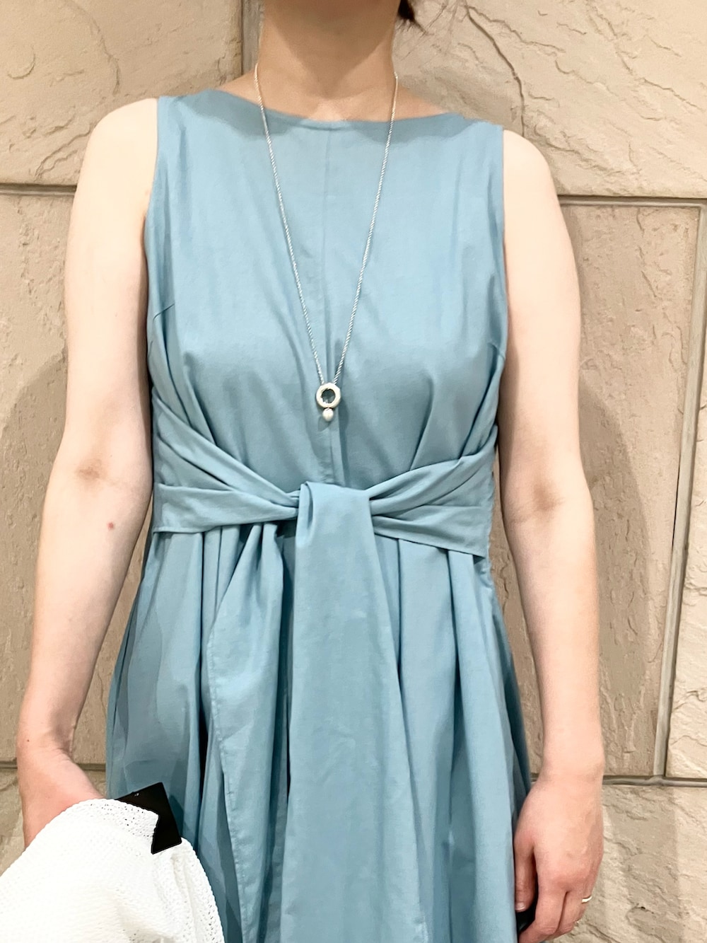 ブルー系のワンピース、ゴールド系のかごバッグ、ホワイト系のカーディガン/ボレロを着用したレディースの夏コーディネートの2枚目の写真