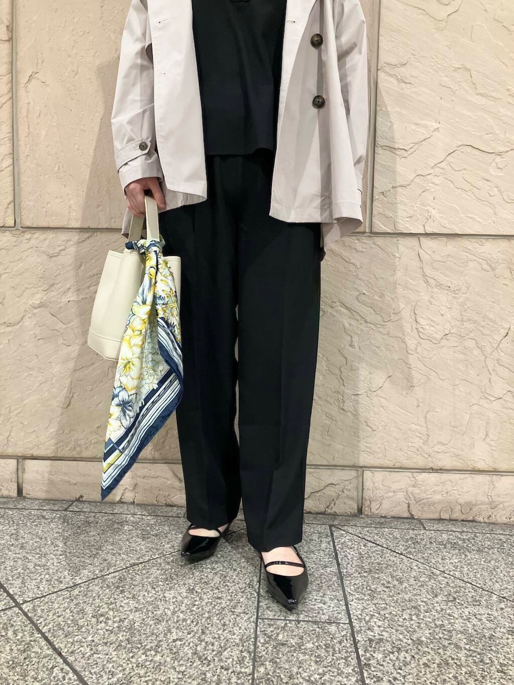 ブラック系のパンプス、ベージュ系のトレンチコート、ホワイト系のハンドバッグを着用したレディースの春コーディネートの6枚目の写真