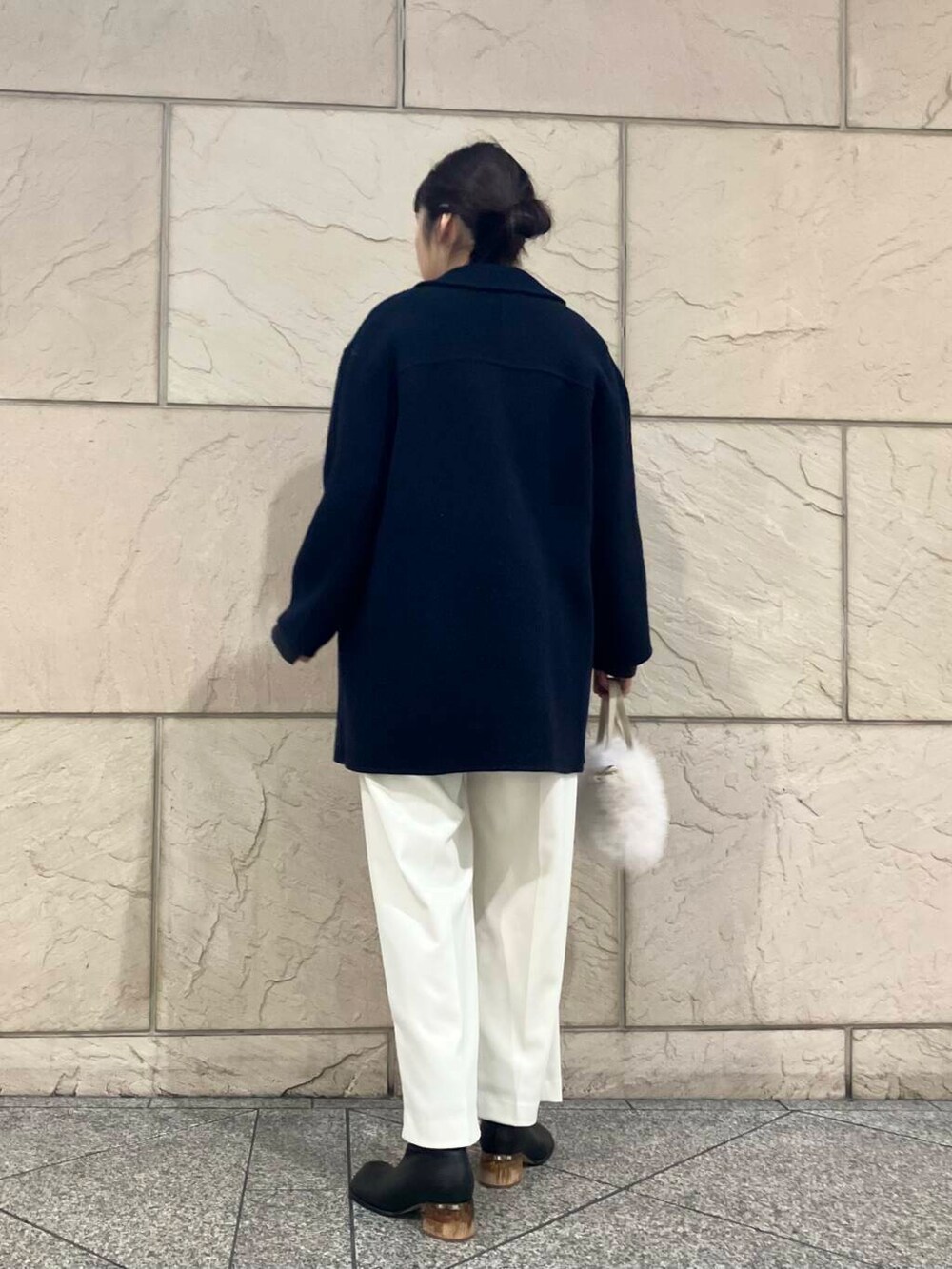 グレー系のニット/セーター、ブルー系のチェスターコート、ホワイト系のその他パンツを着用したレディースの冬コーディネートの3枚目の写真