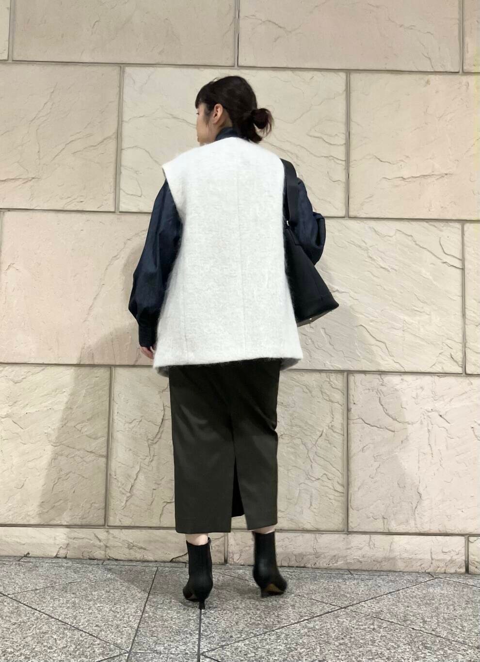 ブラック系のブーツ、グリーン系のスカート、ベージュ系のその他アウターを着用したレディースの秋コーディネートの3枚目の写真