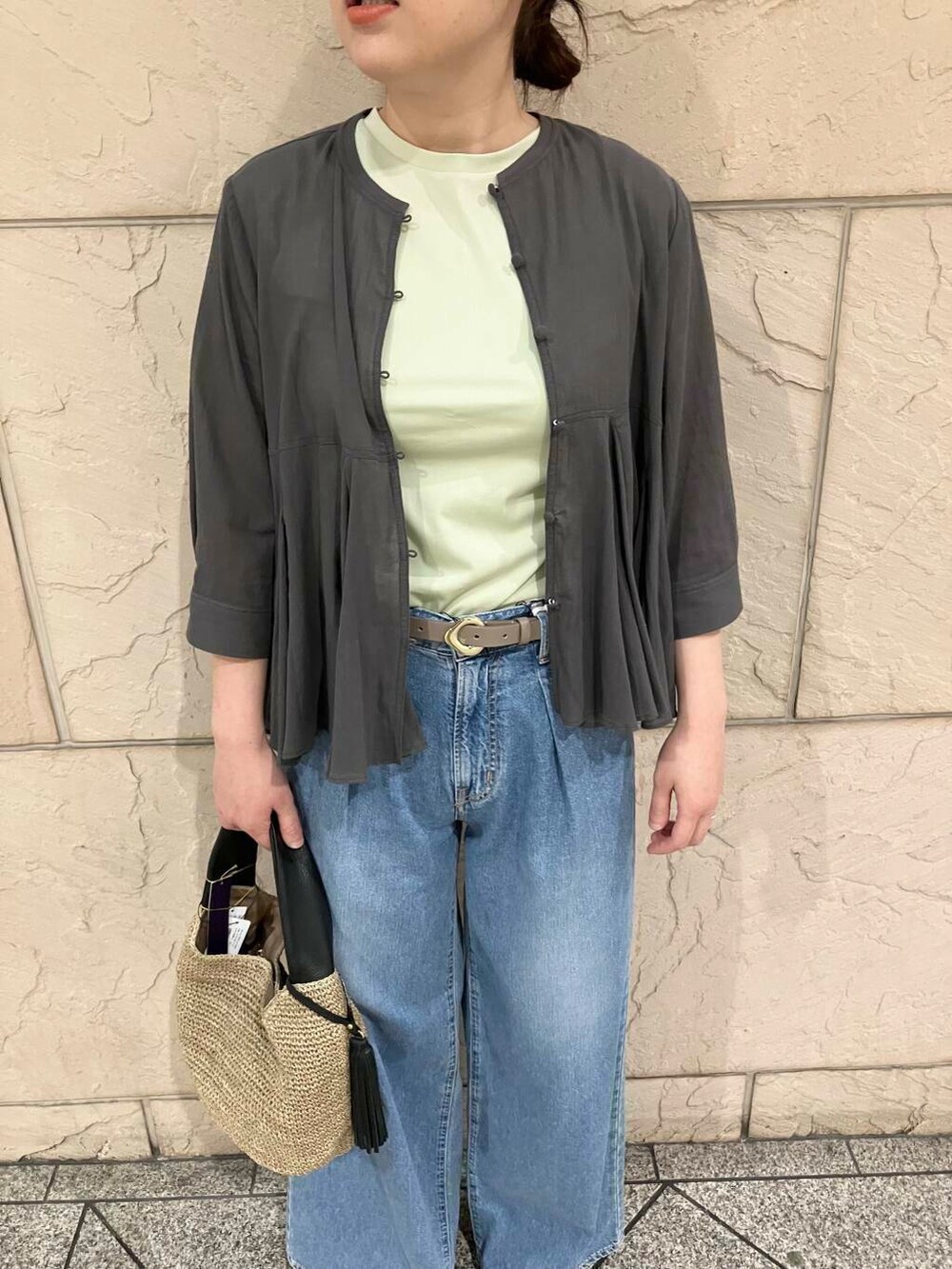 ブラウン系のかごバッグ、グリーン系のTシャツ/カットソー、ブルー系のデニムパンツを着用したレディースの夏コーディネートの4枚目の写真