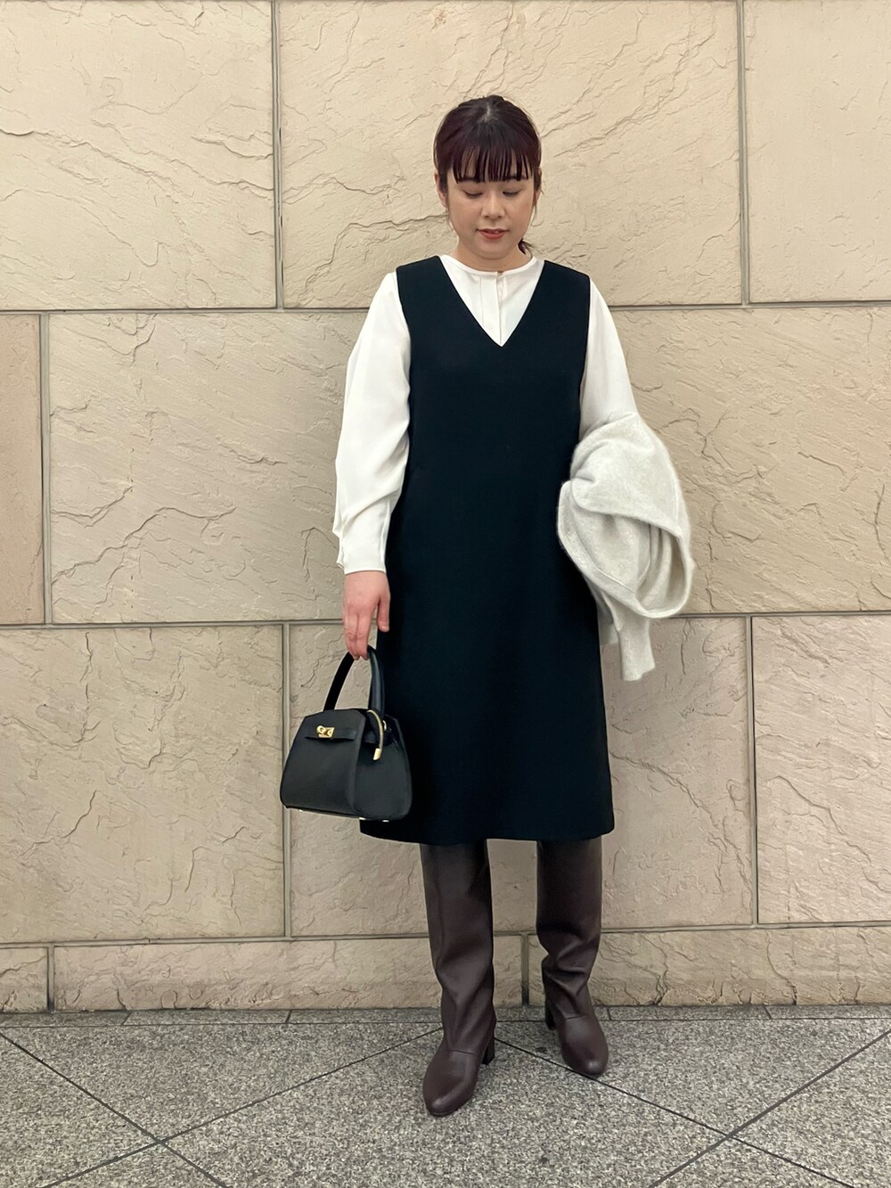 ブラック系のワンピース、ホワイト系のカーディガン/ボレロ、ホワイト系のシャツ/ブラウスを着用したレディースの冬コーディネートの4枚目の写真