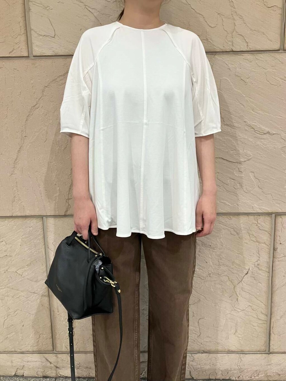 ホワイト系のTシャツ/カットソー、ブラック系のハンドバッグ、グリーン系のパンプスを着用したレディースの夏コーディネートの4枚目の写真