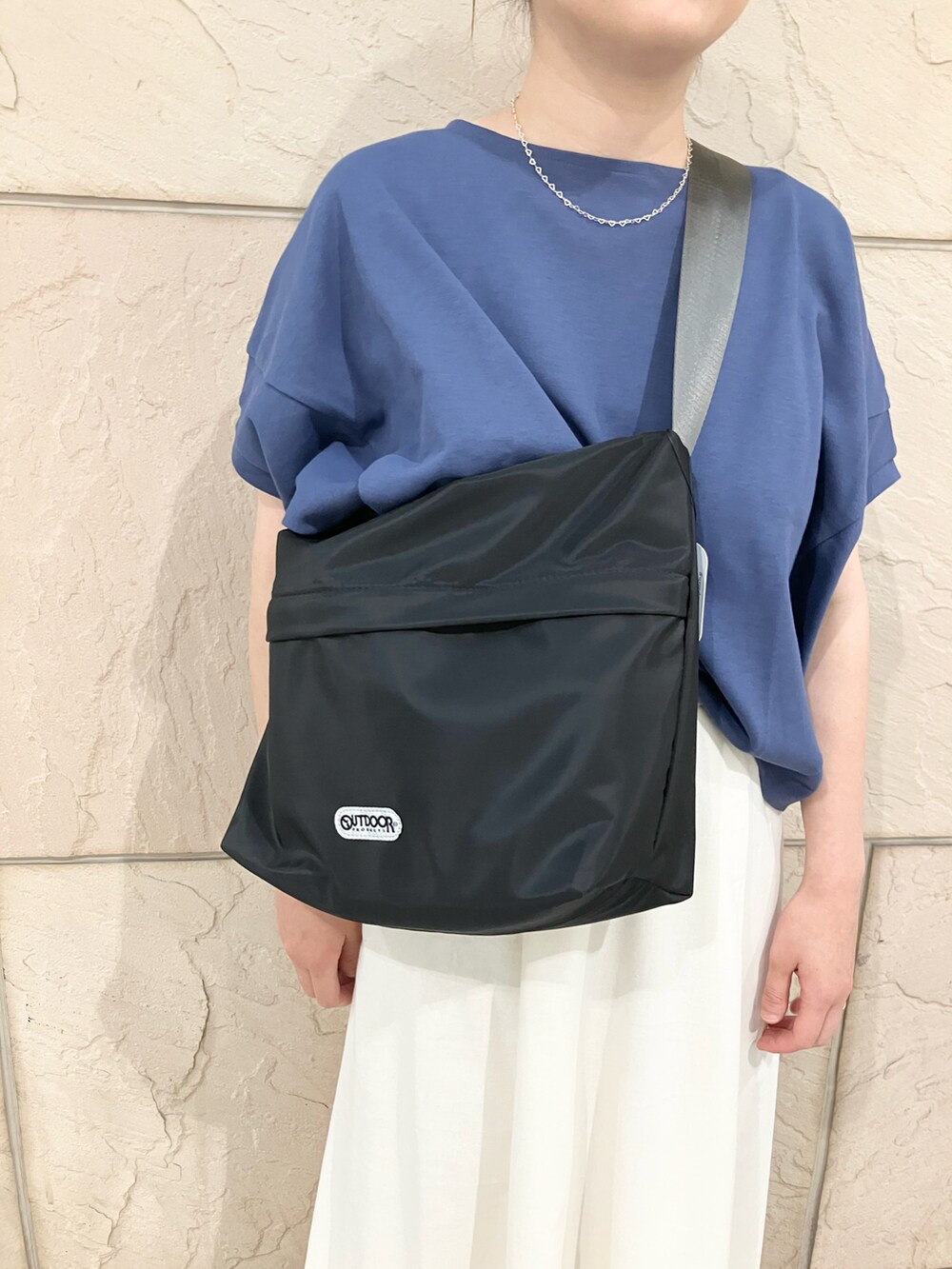 グレー系のTシャツ/カットソー、ホワイト系のスカート、ブルー系のスニーカーを着用したレディースの夏コーディネートの3枚目の写真