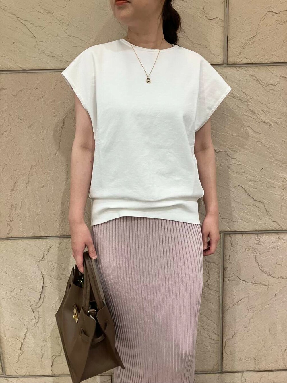 ホワイト系のスウェット、ピンク系のスカート、ベージュ系のパンプスを着用したレディースの夏コーディネートの4枚目の写真