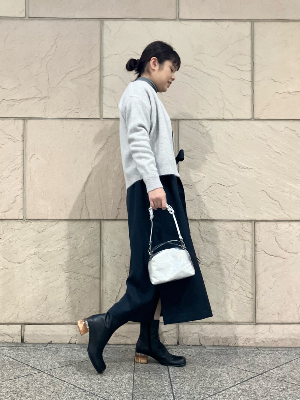 ブルー系のワンピース、グレー系のカーディガン/ボレロ、ブラック系のブーツを着用したレディースの秋コーディネートの2枚目の写真