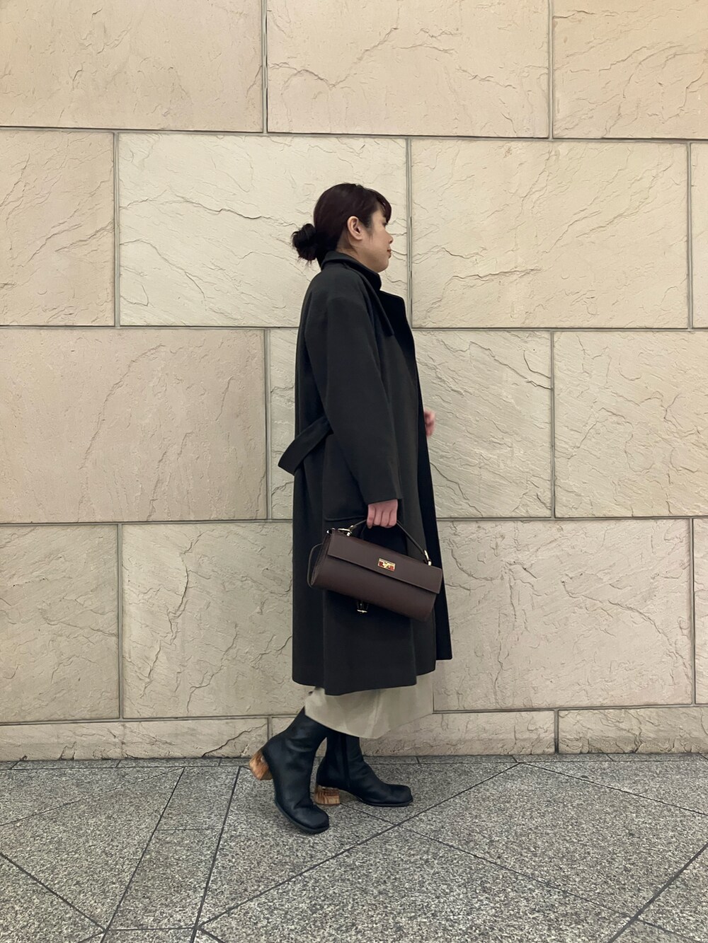 グリーン系のニット/セーター、ブラウン系のその他アウター、ベージュ系のスカートを着用したレディースの冬コーディネートの2枚目の写真