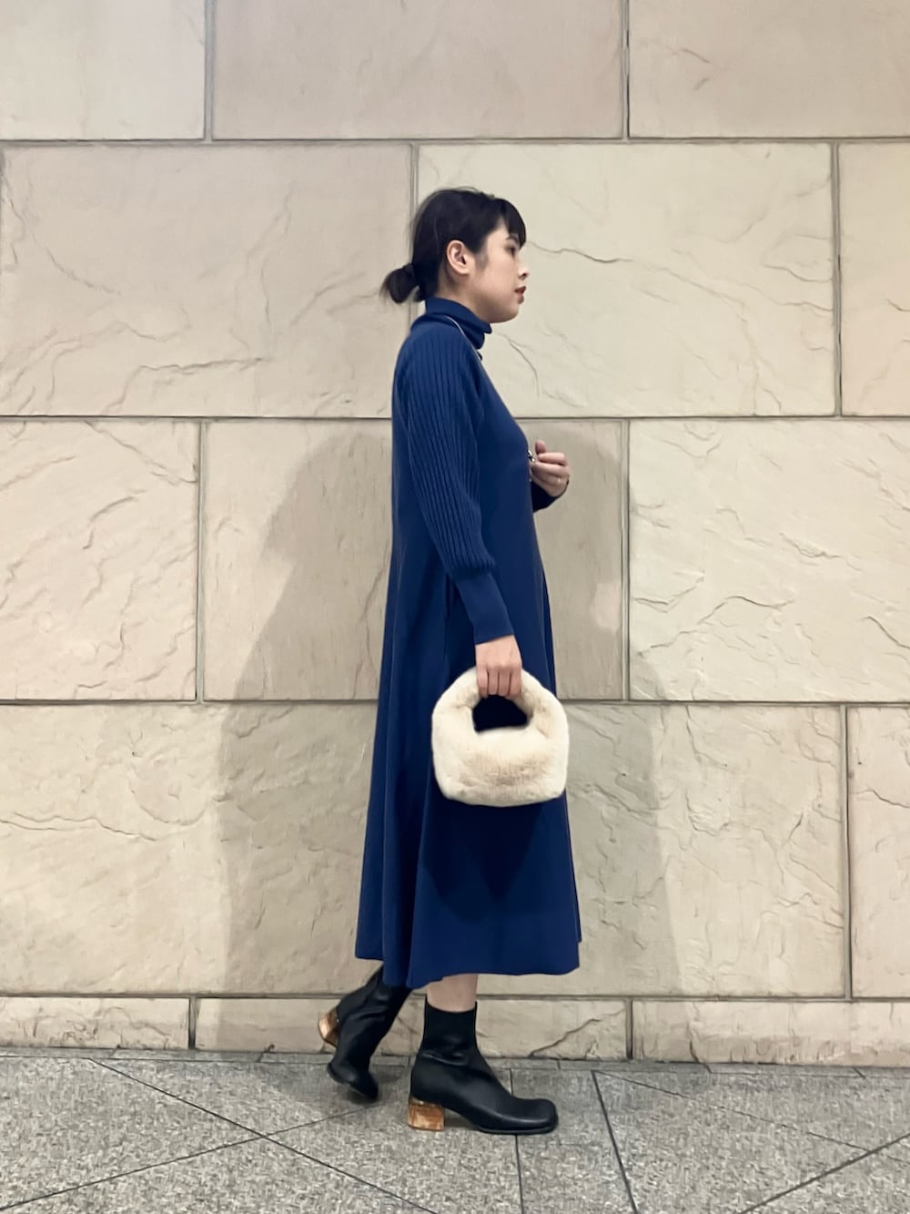 ブルー系のワンピース、ブラック系のブーツ、シルバー系のネックレスを着用したレディースの秋コーディネートの2枚目の写真