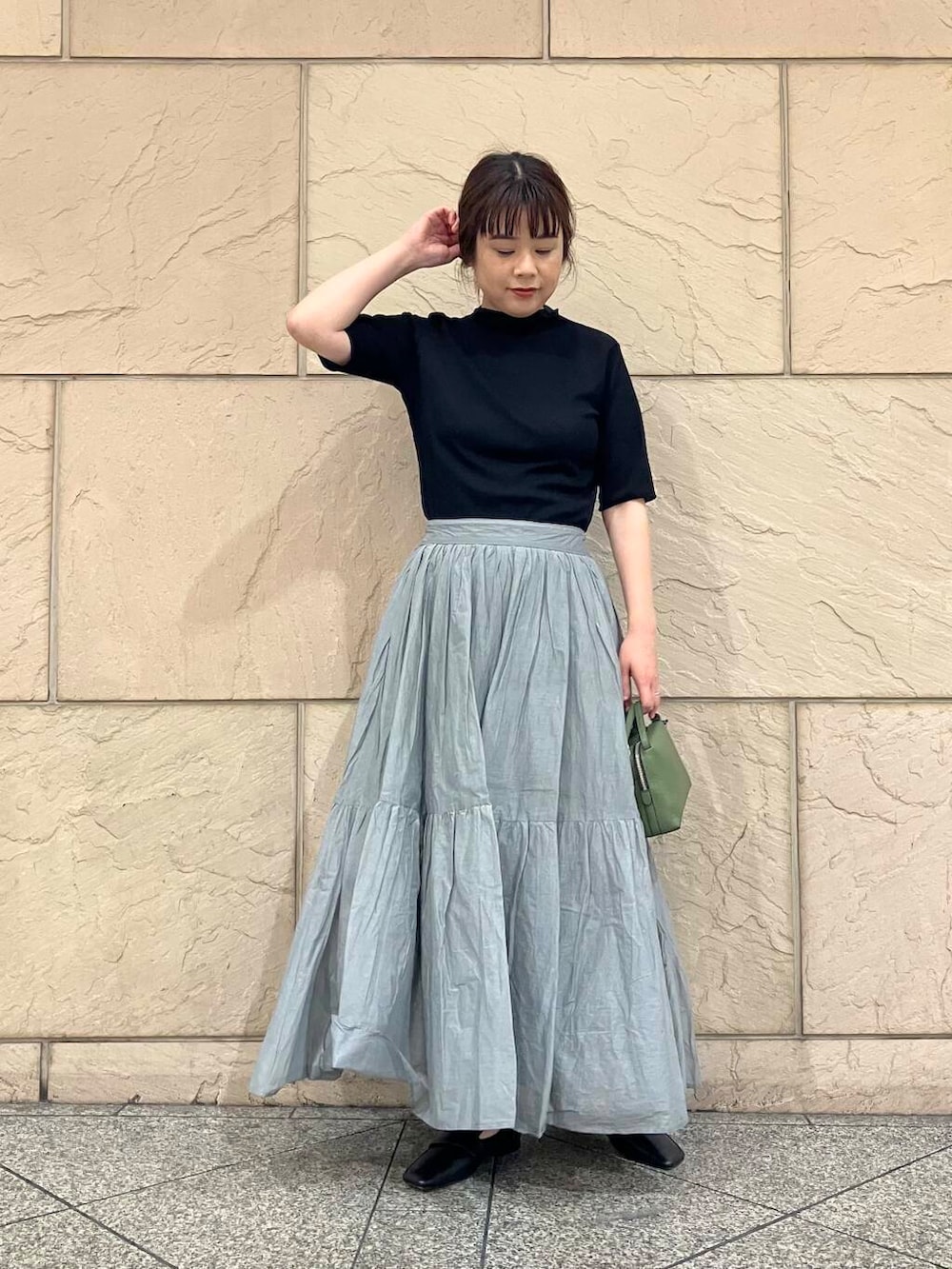 ブラック系のTシャツ/カットソー、グレー系のスカート、グリーン系のショルダーバッグを着用したレディースの夏コーディネートの2枚目の写真