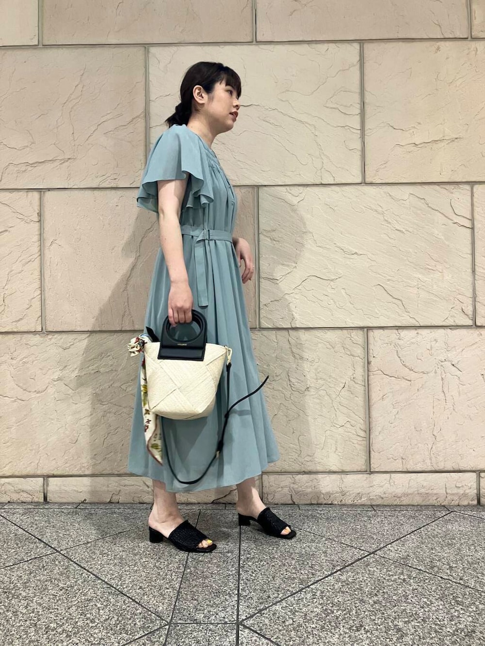 ベージュ系のショルダーバッグ、ブルー系のワンピース、ホワイト系のバンダナ/スカーフを着用したレディースの春コーディネートの3枚目の写真