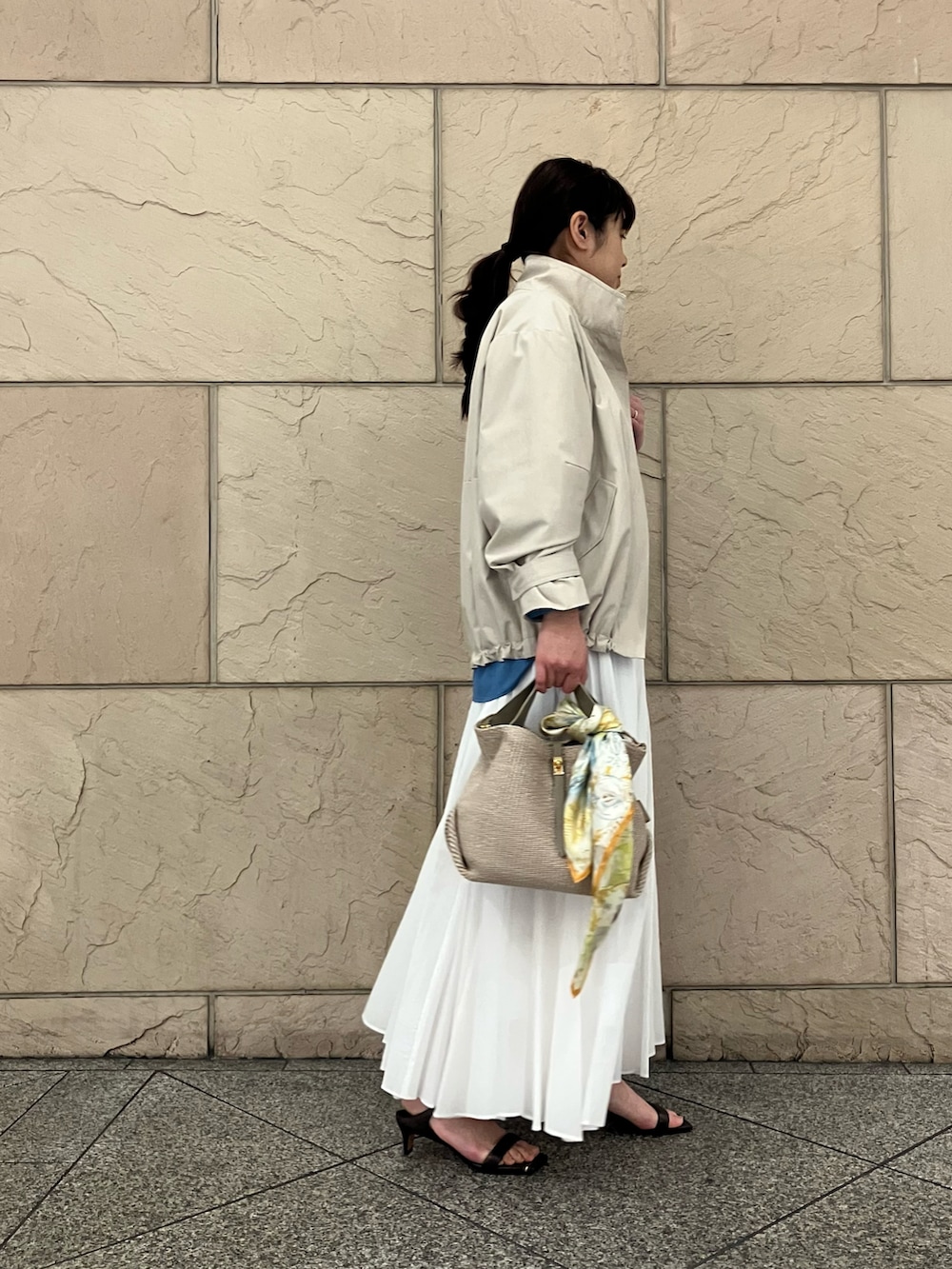 ブルー系のシャツ/ブラウス、ベージュ系のその他アウター、ホワイト系のスカートを着用したレディースの春コーディネートの2枚目の写真