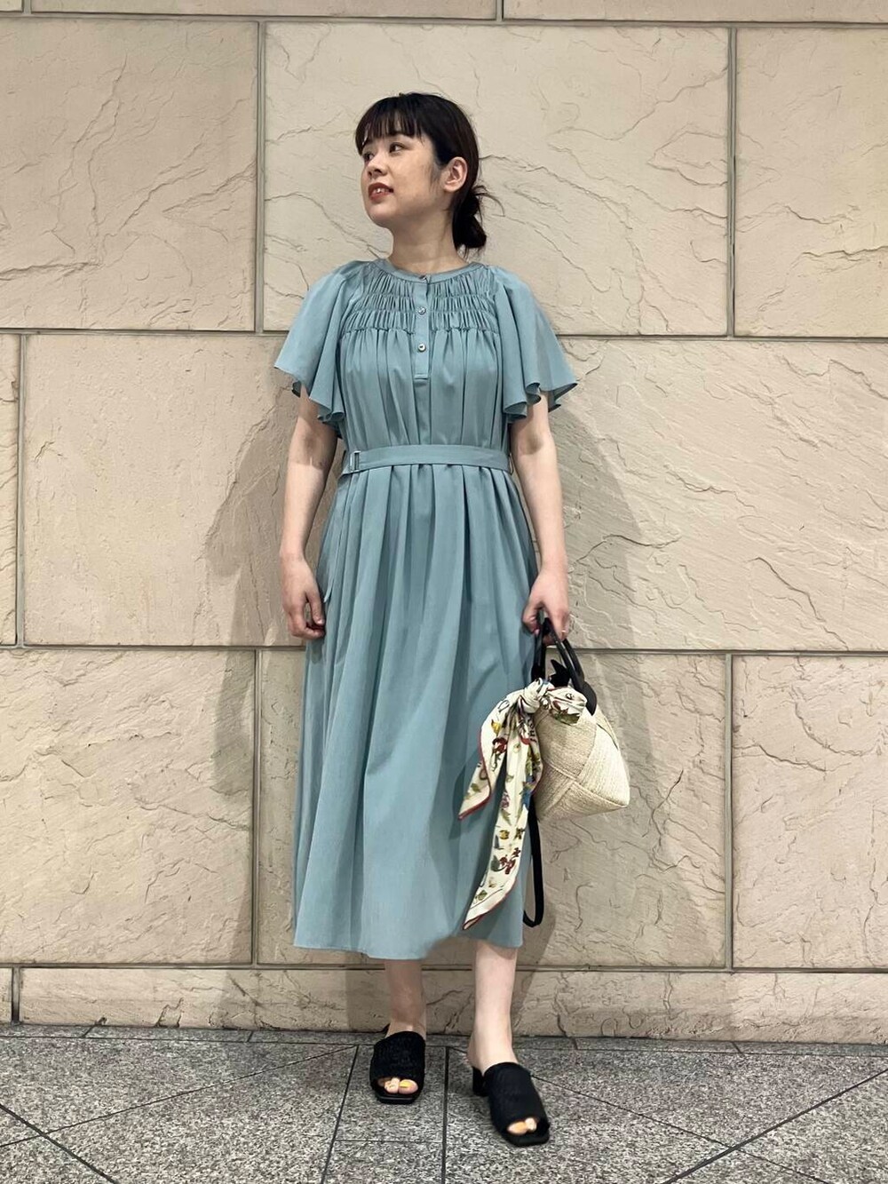 ベージュ系のショルダーバッグ、ブルー系のワンピース、ホワイト系のバンダナ/スカーフを着用したレディースの春コーディネートの2枚目の写真