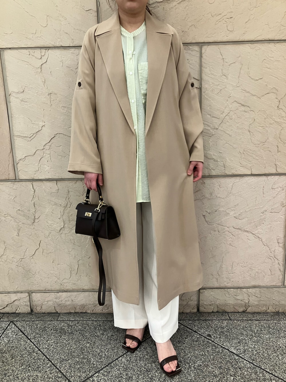 ベージュ系のトレンチコート、ホワイト系のその他パンツ、イエロー系のシャツ/ブラウスを着用したレディースの春コーディネートの4枚目の写真