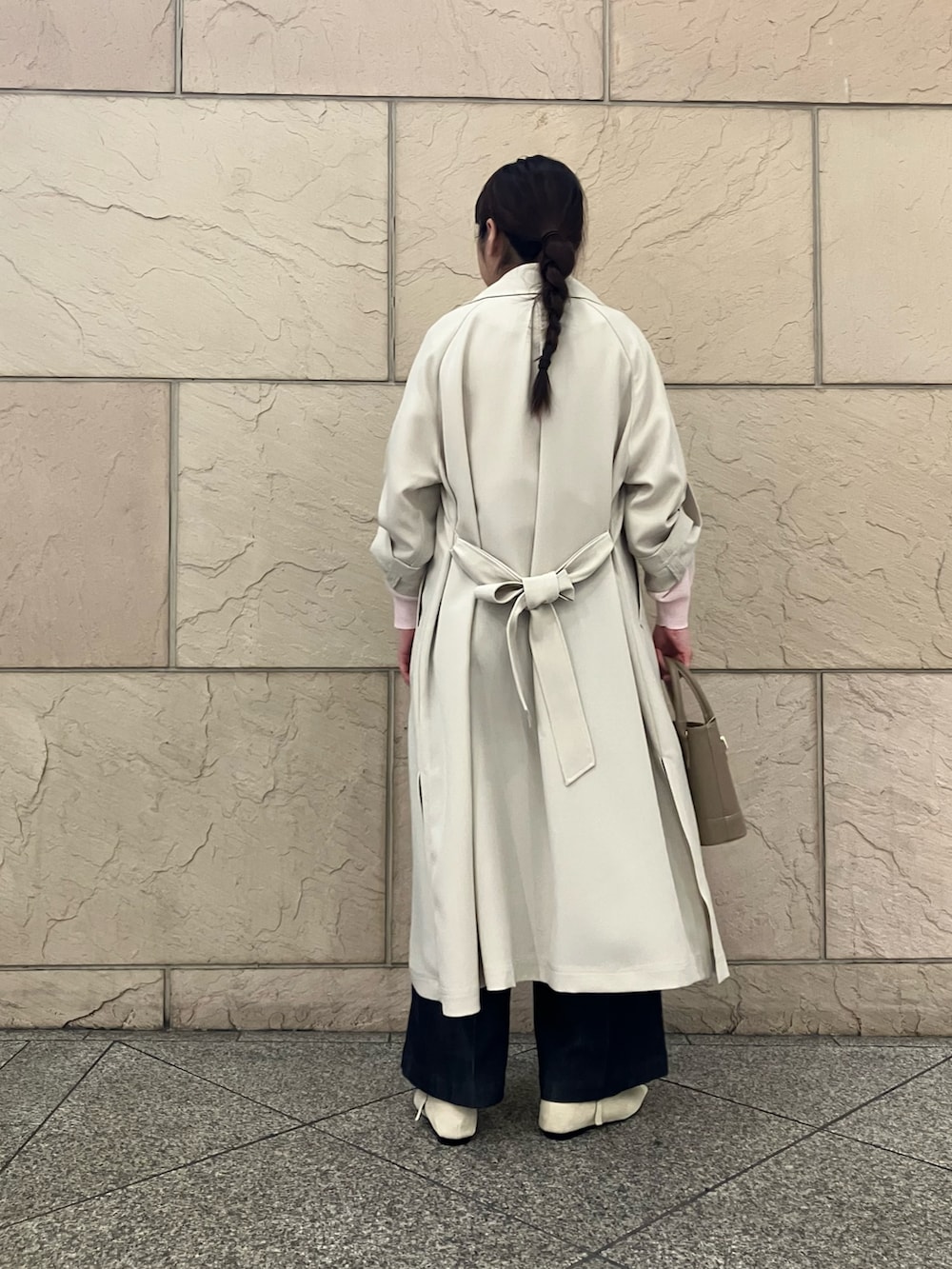 ピンク系のニット/セーター、ホワイト系のトレンチコート、ブルー系のデニムパンツを着用したレディースの春コーディネートの3枚目の写真