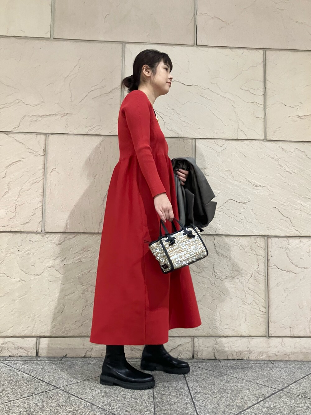 レッド系のワンピース、グレー系のその他アウター、ブラック系のブーツを着用したレディースの秋コーディネートの4枚目の写真