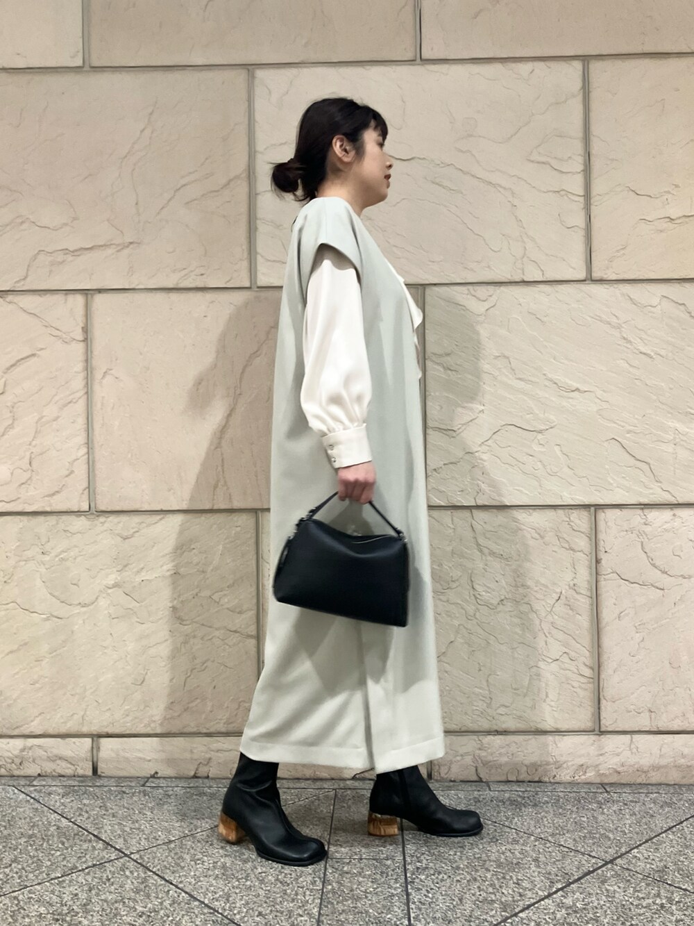 ホワイト系のワンピース、ホワイト系のシャツ/ブラウス、ブラック系のブーツを着用したレディースの冬コーディネートの2枚目の写真