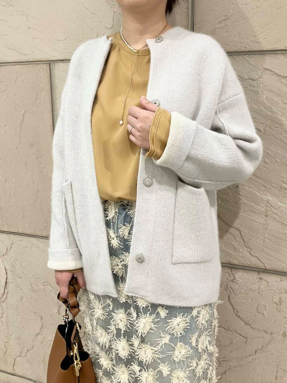 ブルー系のデニムパンツ、グレー系のカーディガン/ボレロ、イエロー系のシャツ/ブラウスを着用したレディースの秋コーディネートの4枚目の写真