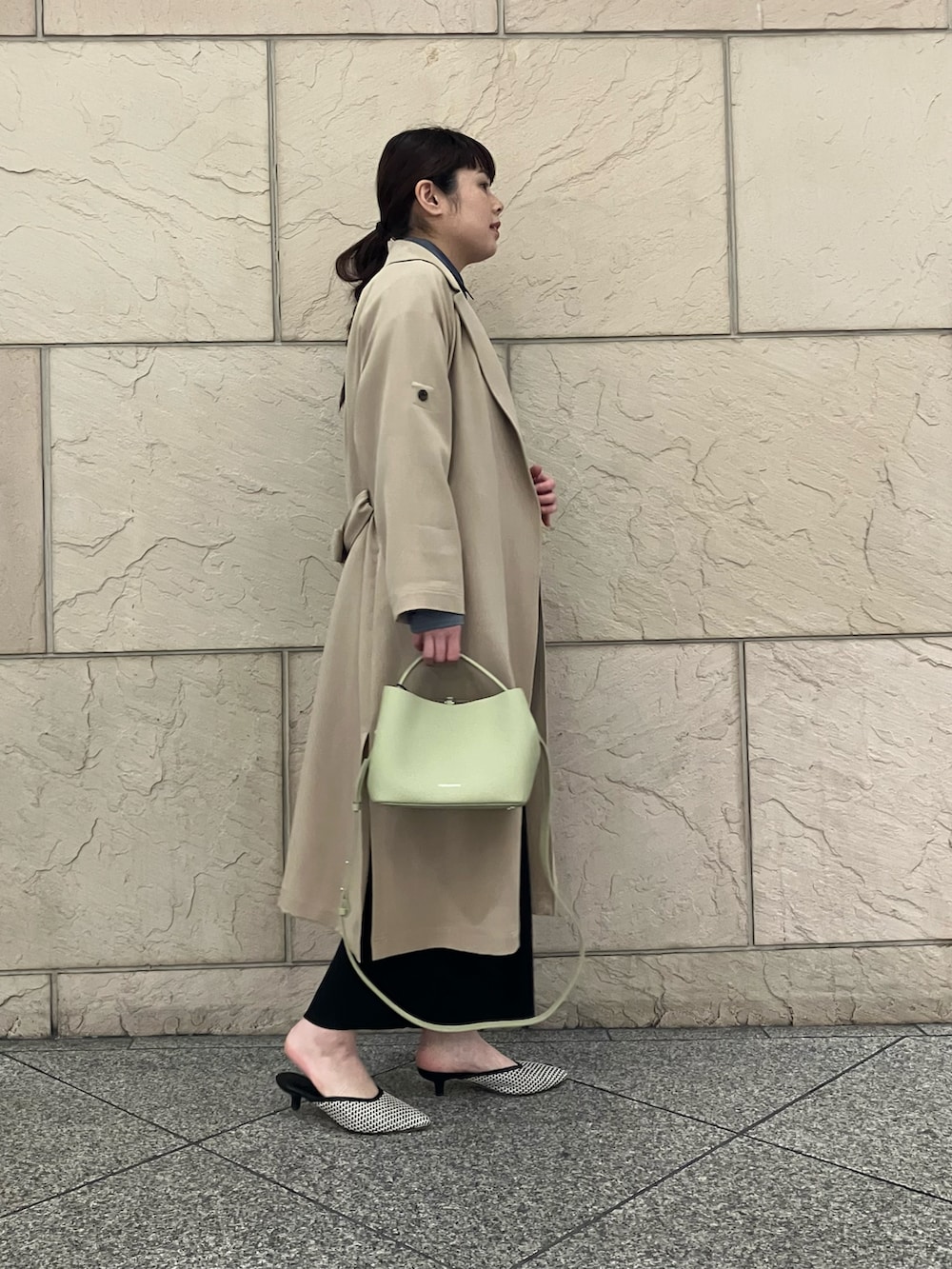 ブルー系のシャツ/ブラウス、ブラック系のスカート、ベージュ系のトレンチコートを着用したレディースの冬コーディネートの2枚目の写真