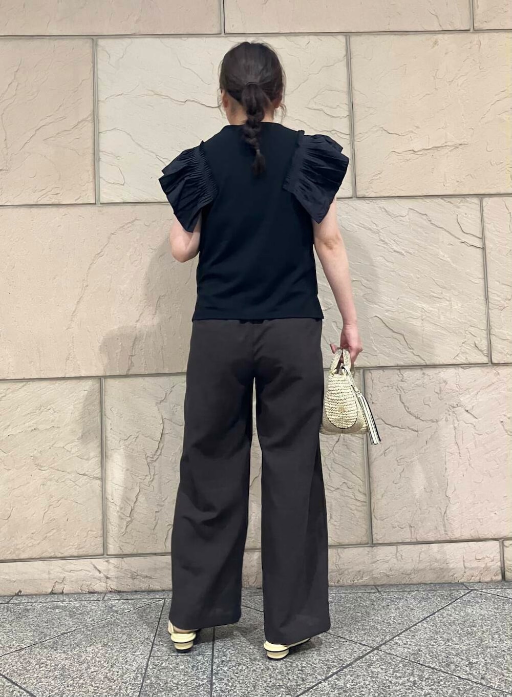 ベージュ系のかごバッグ、イエロー系のサンダル、ブラック系のTシャツ/カットソーを着用したレディースの夏コーディネートの2枚目の写真