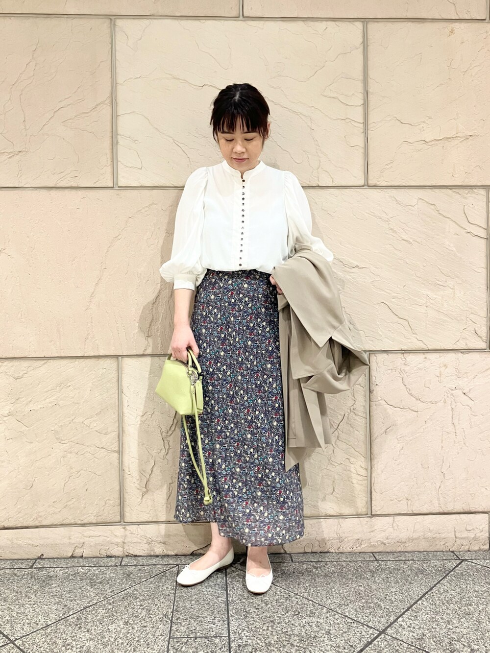 ベージュ系のトレンチコート、ブラック系のスカート、ホワイト系のシャツ/ブラウスを着用したレディースの春コーディネートの4枚目の写真