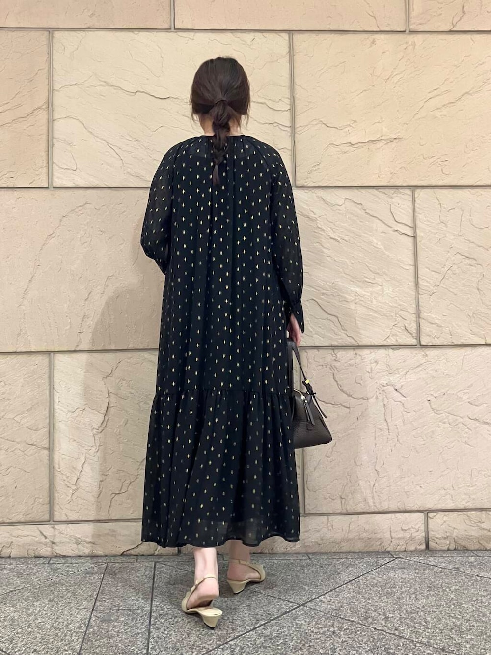 ブラック系のワンピース、ベージュ系のパンプス、ブラウン系のバッグを着用したレディースの夏コーディネートの3枚目の写真