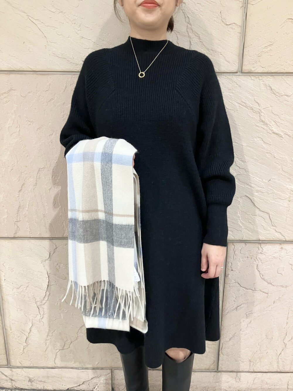 ブラック系のワンピース、ブラック系のブーツ、ホワイト系のストール/ショールを着用したレディースの秋コーディネートの5枚目の写真