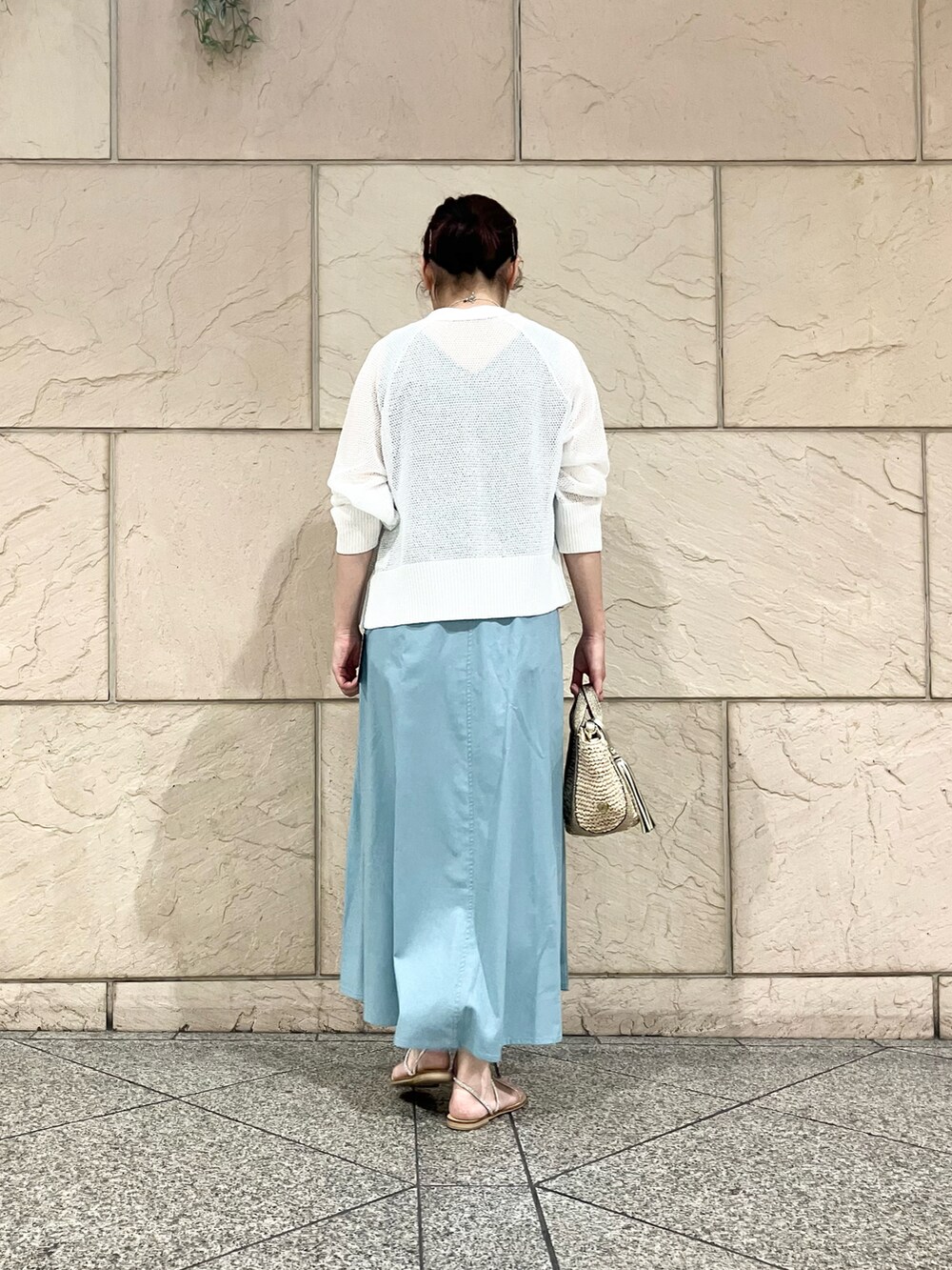 ブルー系のワンピース、ゴールド系のかごバッグ、ホワイト系のカーディガン/ボレロを着用したレディースの夏コーディネートの5枚目の写真