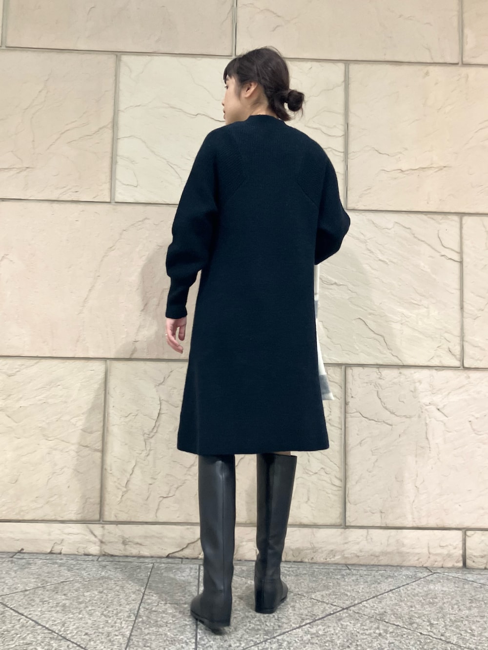 ブラック系のワンピース、ブラック系のブーツ、ホワイト系のストール/ショールを着用したレディースの秋コーディネートの3枚目の写真