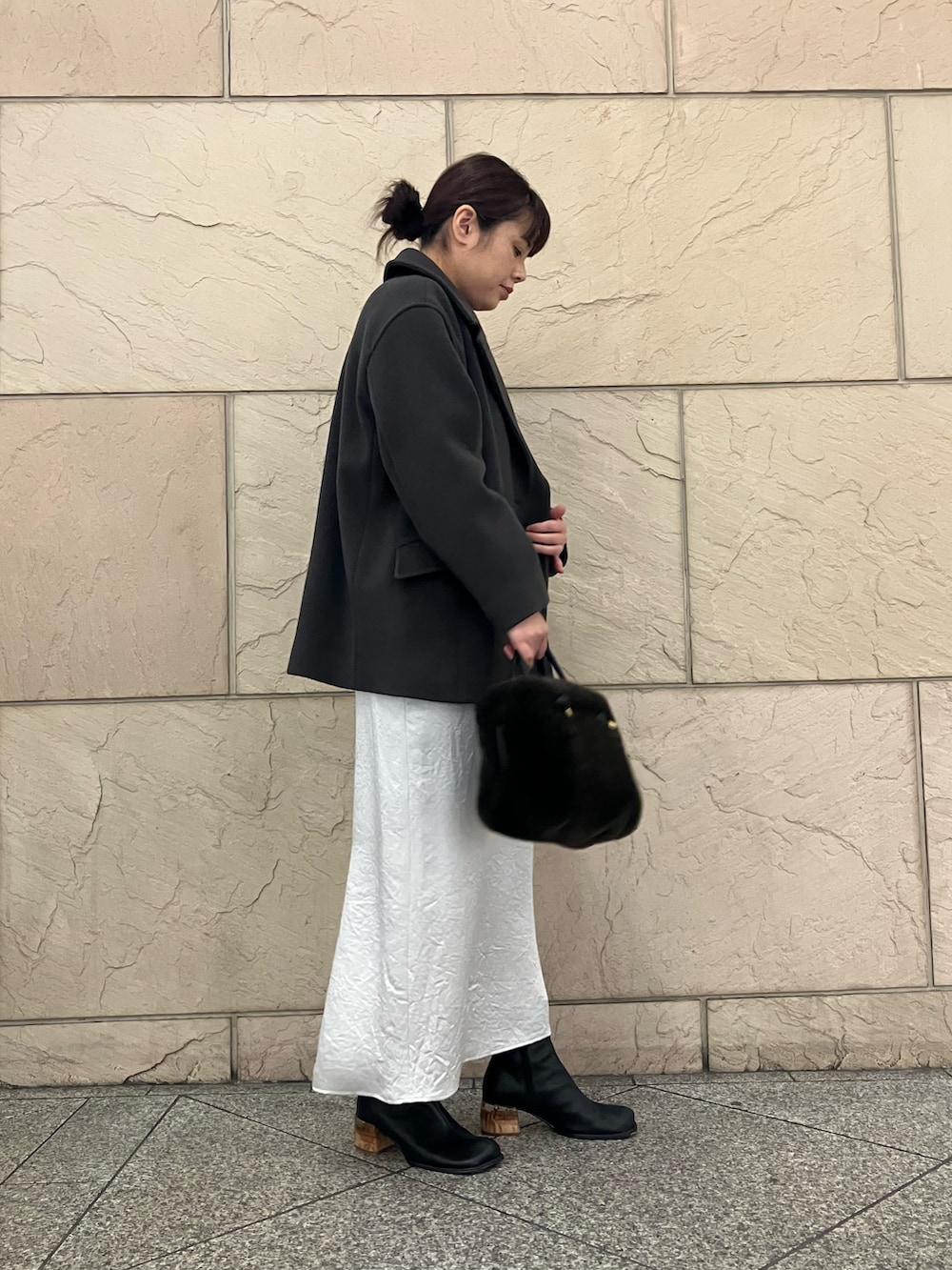 グレー系のニット/セーター、グレー系のピーコート、ブラウン系のハンドバッグを着用したレディースの秋コーディネートの2枚目の写真